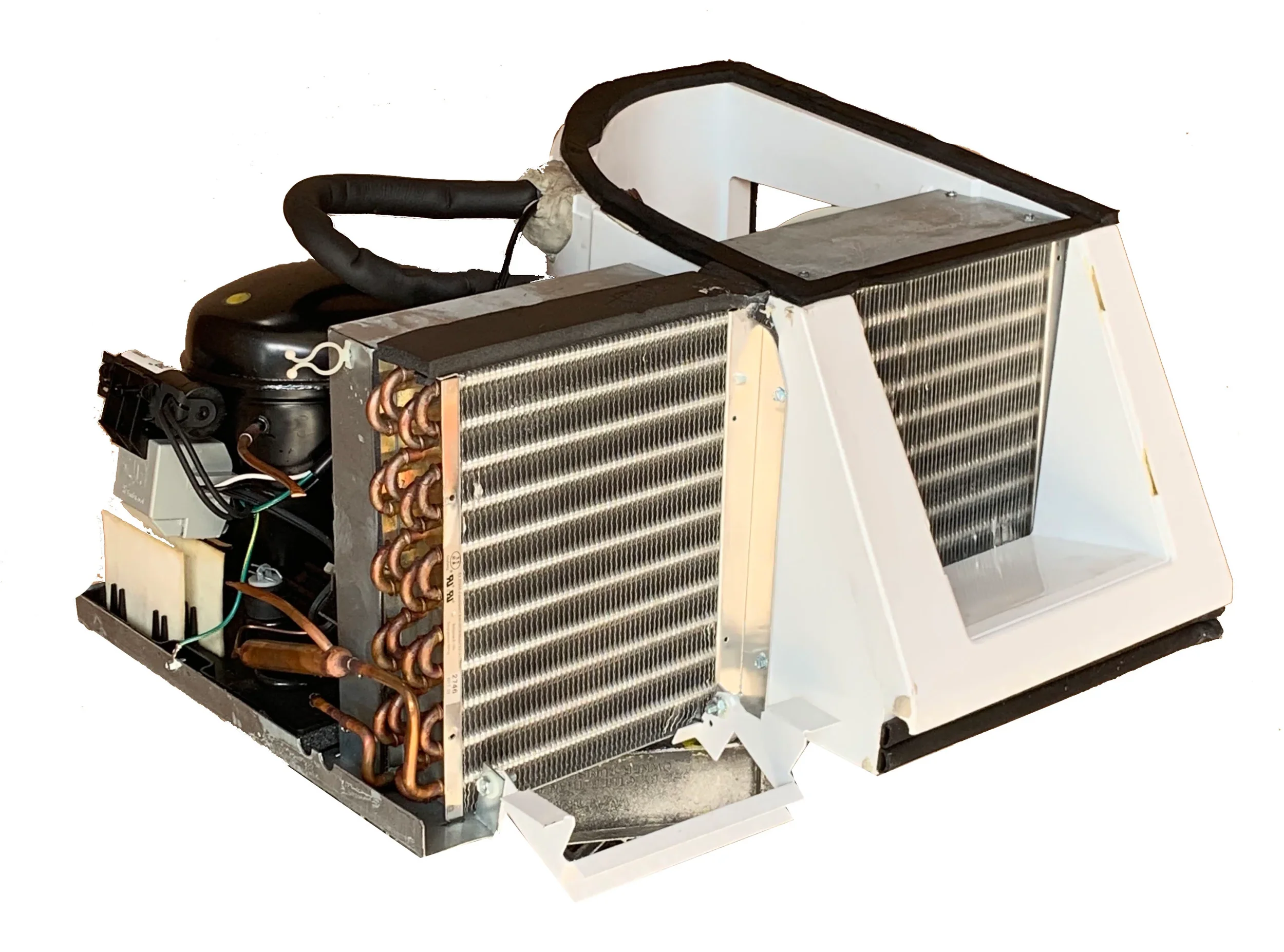 A partially disassembled computer cooling unit with a metal heatsink, copper pipes, a black compressor or fan component, and wiring, set against a plain white background.