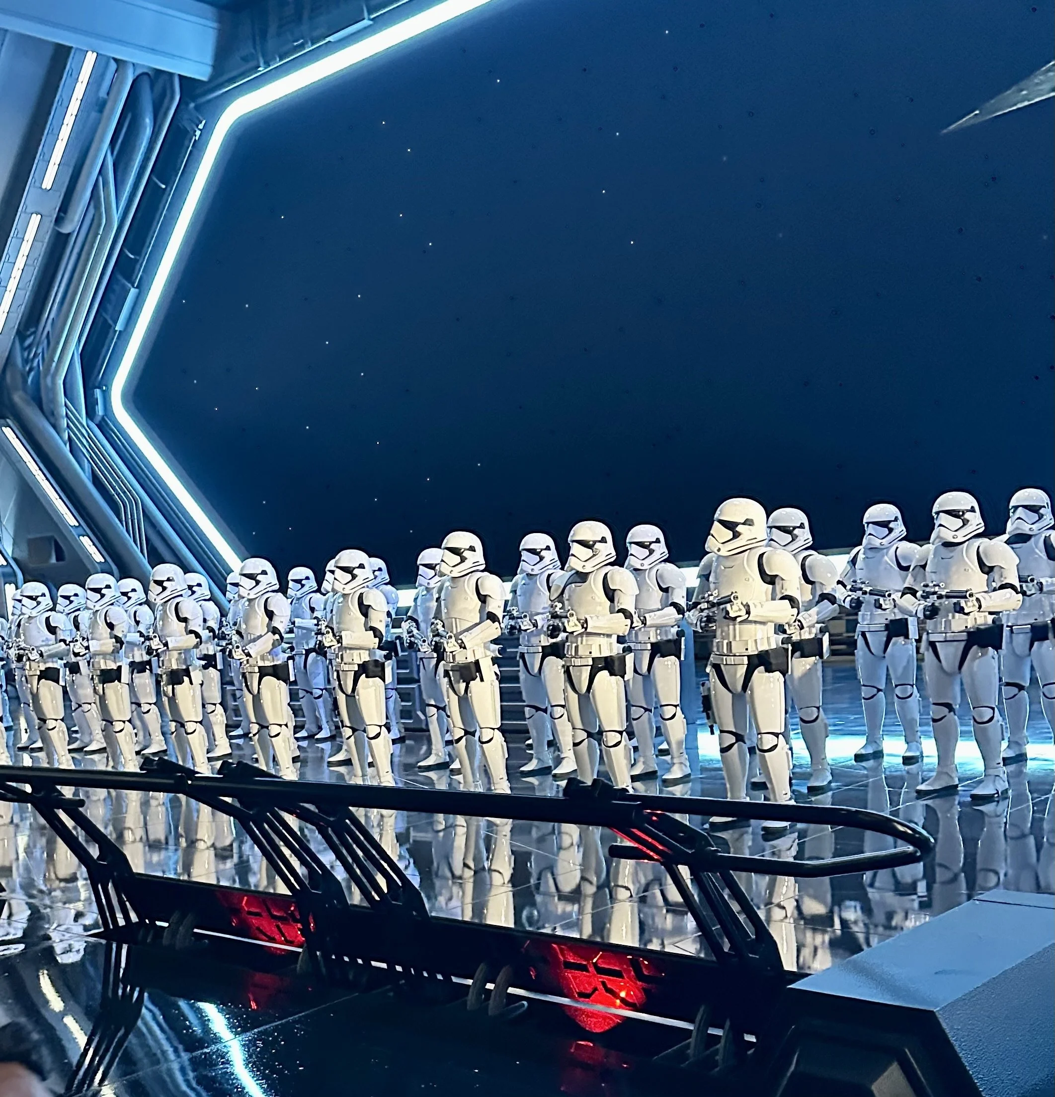 Scene from Rise of the Resistance at Galaxy's Edge in Disneyland, California featuring a line of Stormtroopers, set against a sci-fi background with bright, glowing blue and red lighting.