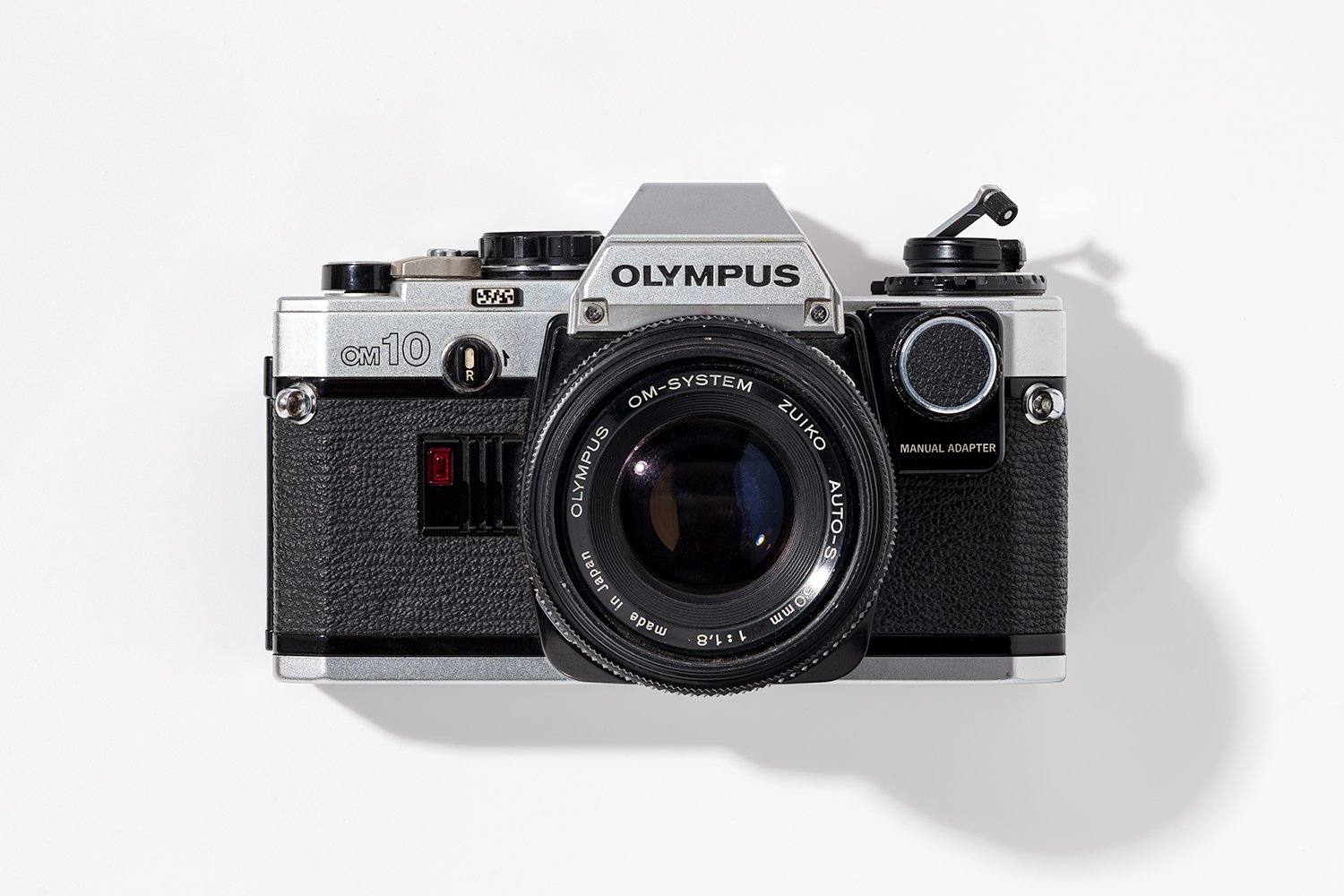 Vintage Olympus OM-10 film camera with a Zuiko 50mm lens on a white background.