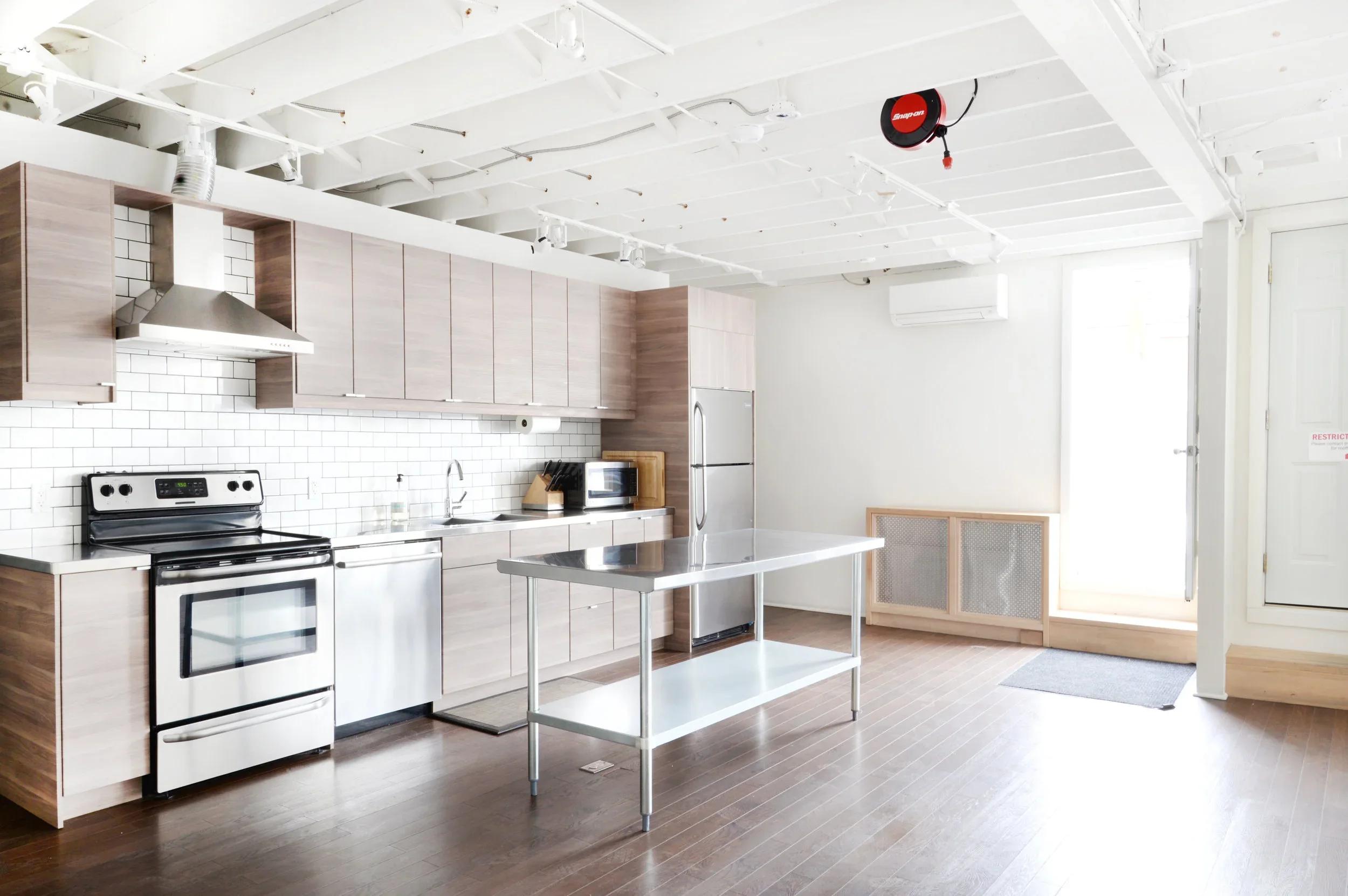 Bright loft style studio with modern, neutral kitchen 