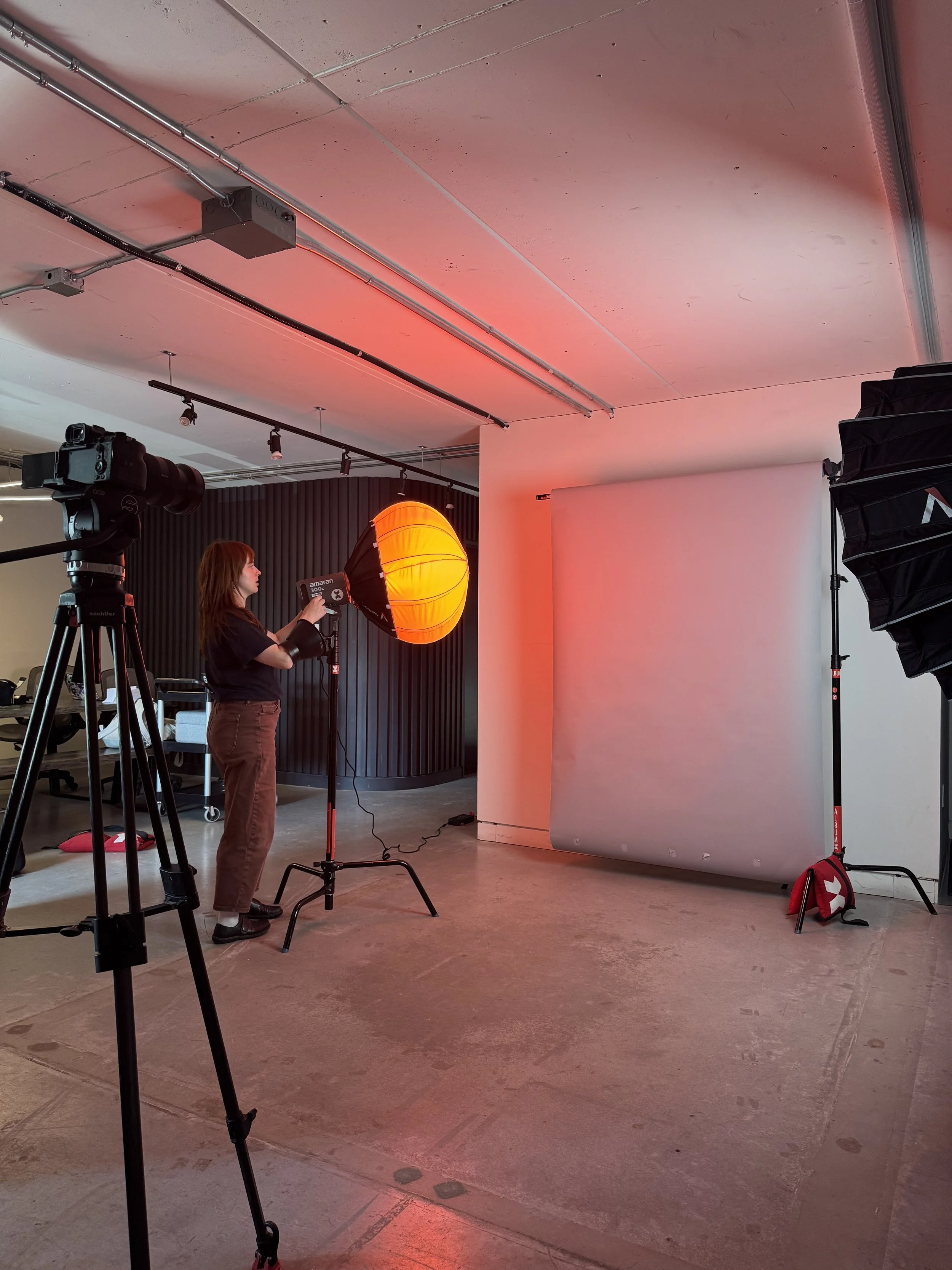 Photoshoot set up. Photography equipment include camera, tripod stand, sandbags, seamless backdrop, lights