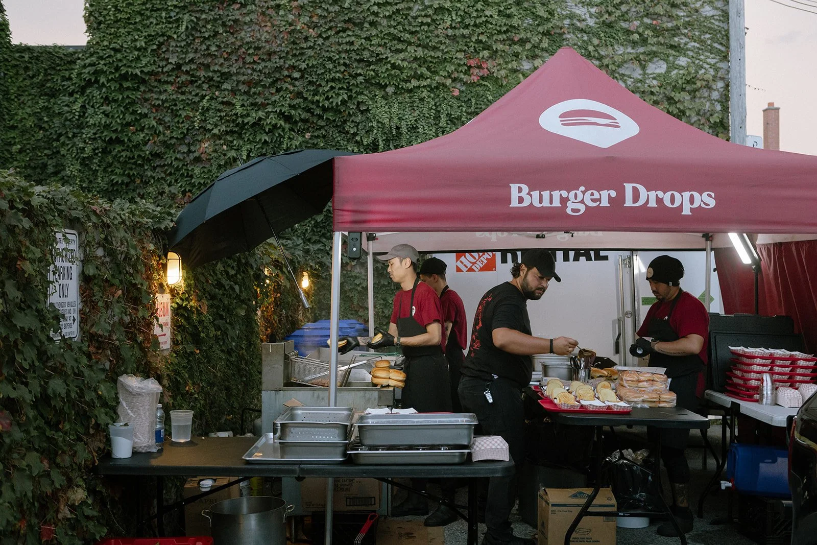 Staff of Burger Drops preparing burgers outside the patio of a Toronto event venue and studio
