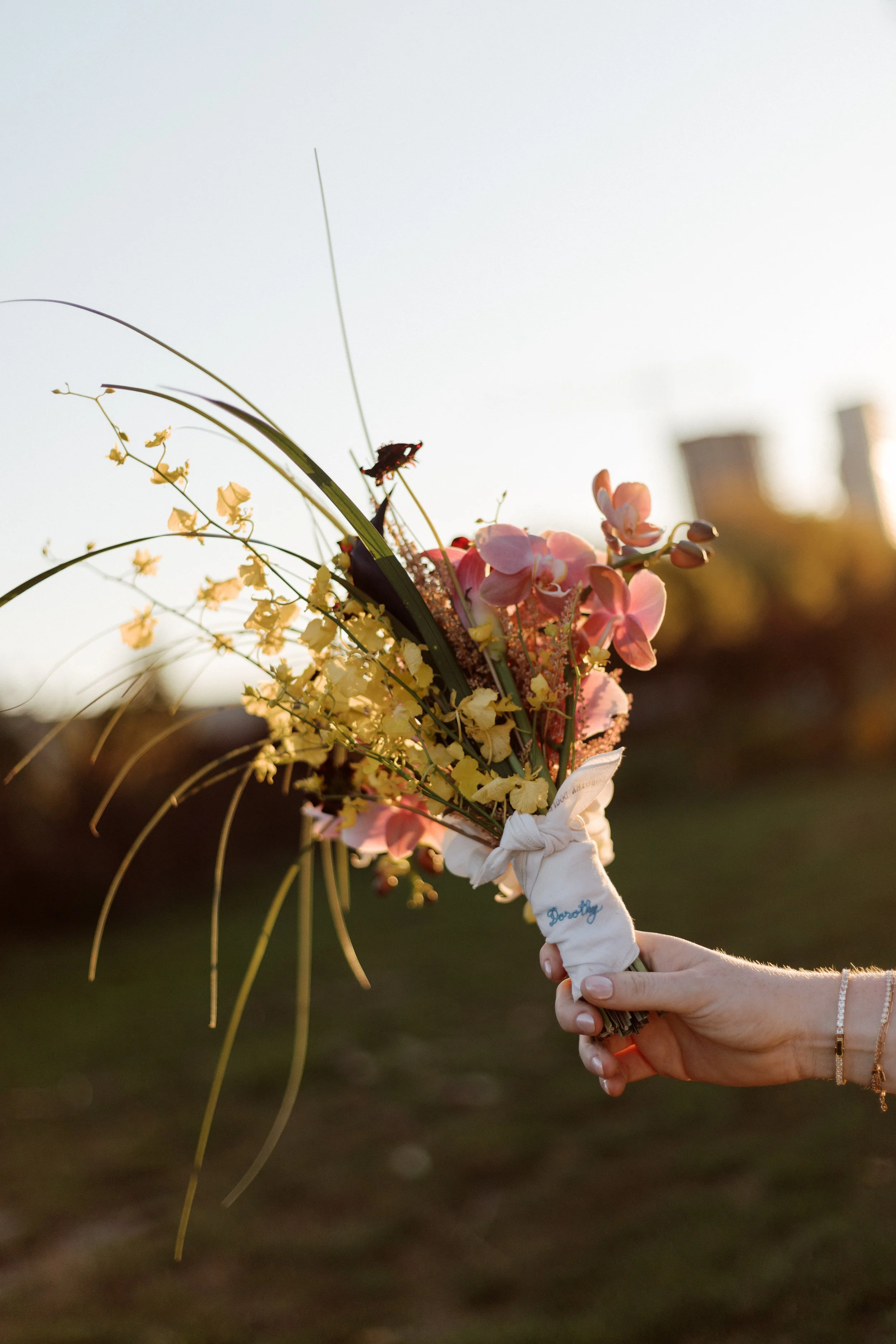 Wedding flowers held by a hand during sunset