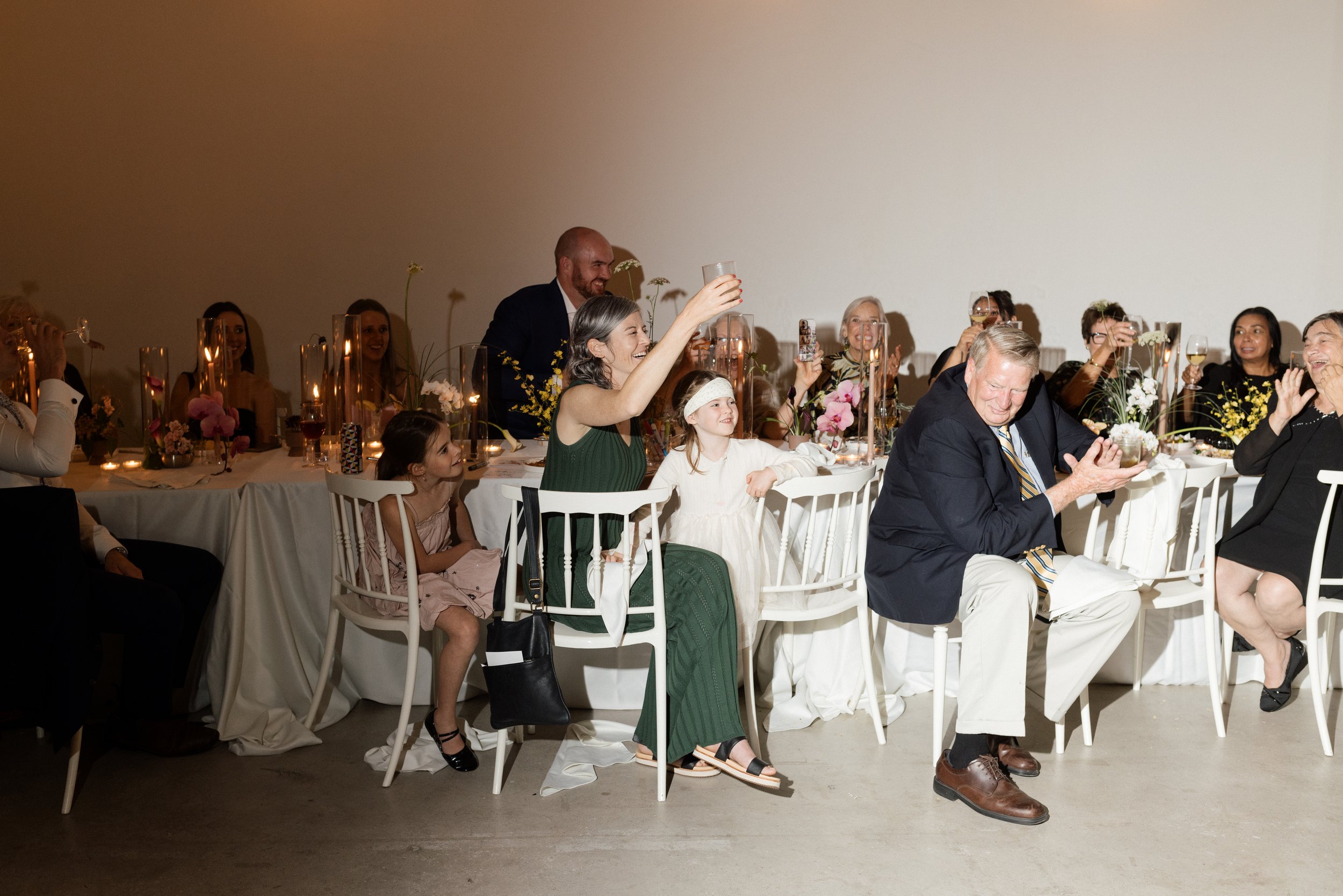 Wedding guests clapping and raising their glasses 