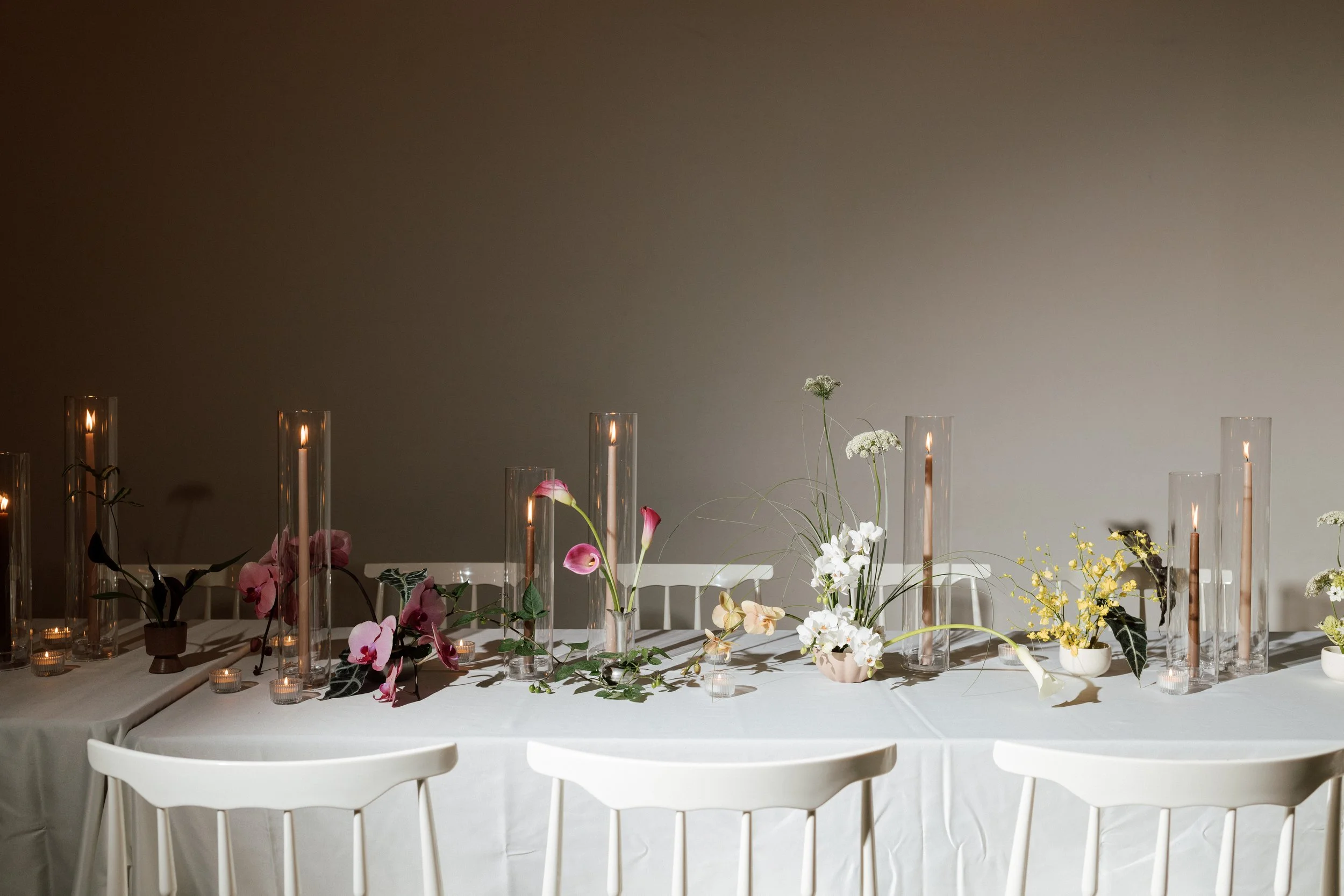 Florals and candles brighten a wedding guest table 