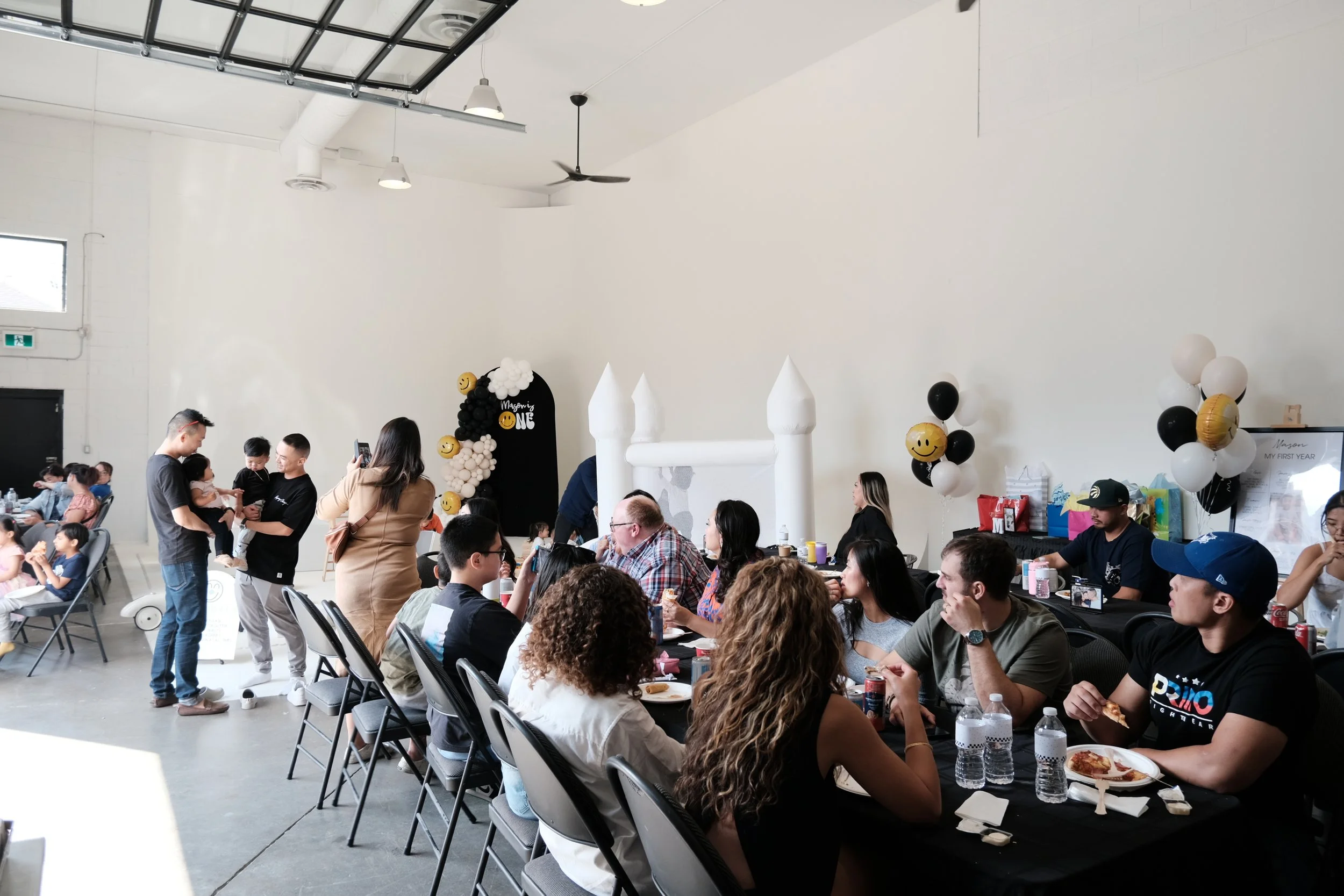 A bouncy castle is placed on a cyclorama found inside a Toronto studio rental space and event venue. There’s a birthday party sign and people seated around a long dining table.