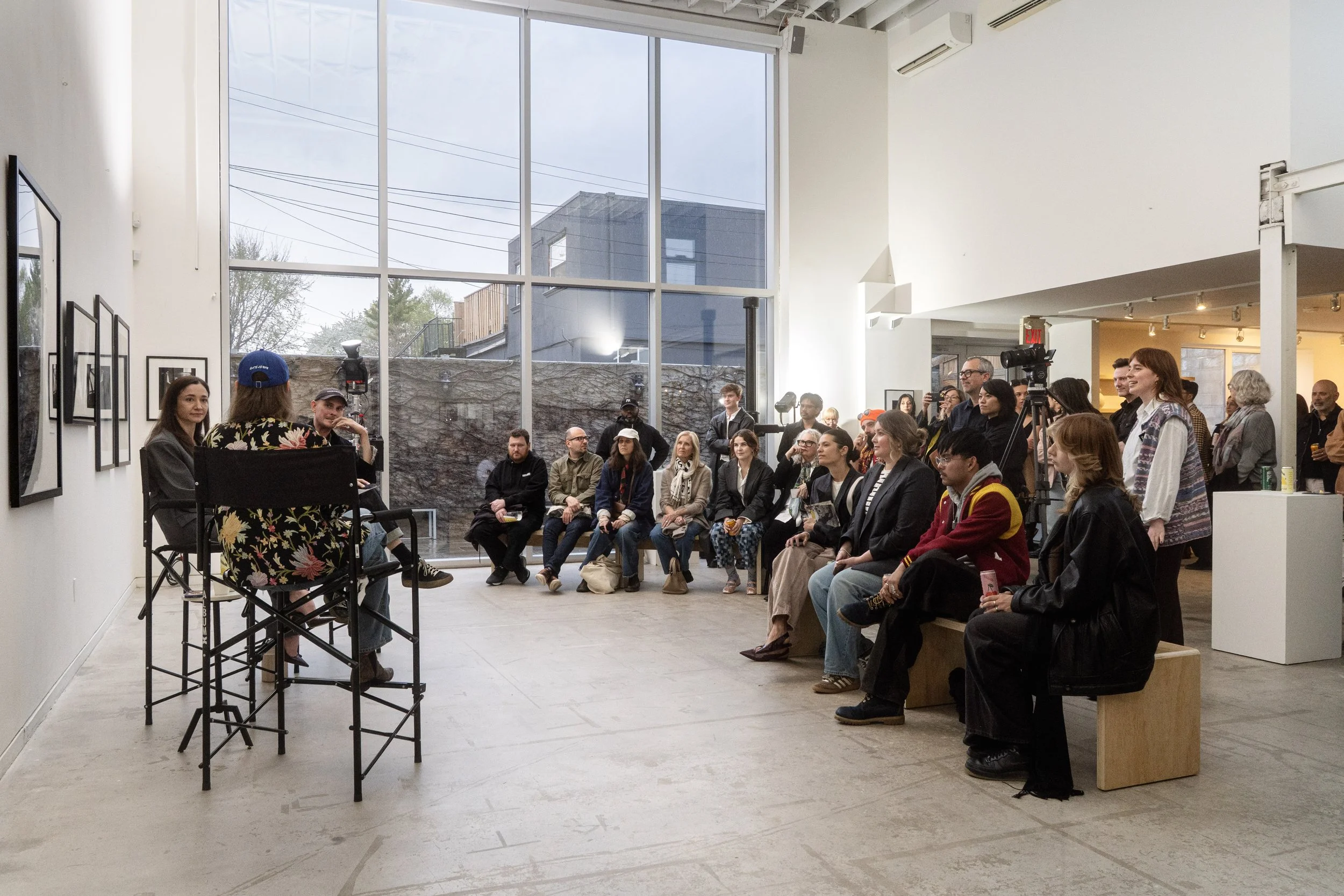 Guests listen to a live interview with photographers Karolina Kuras and Ted Belton for their opening gallery exhibition of black and white photography.