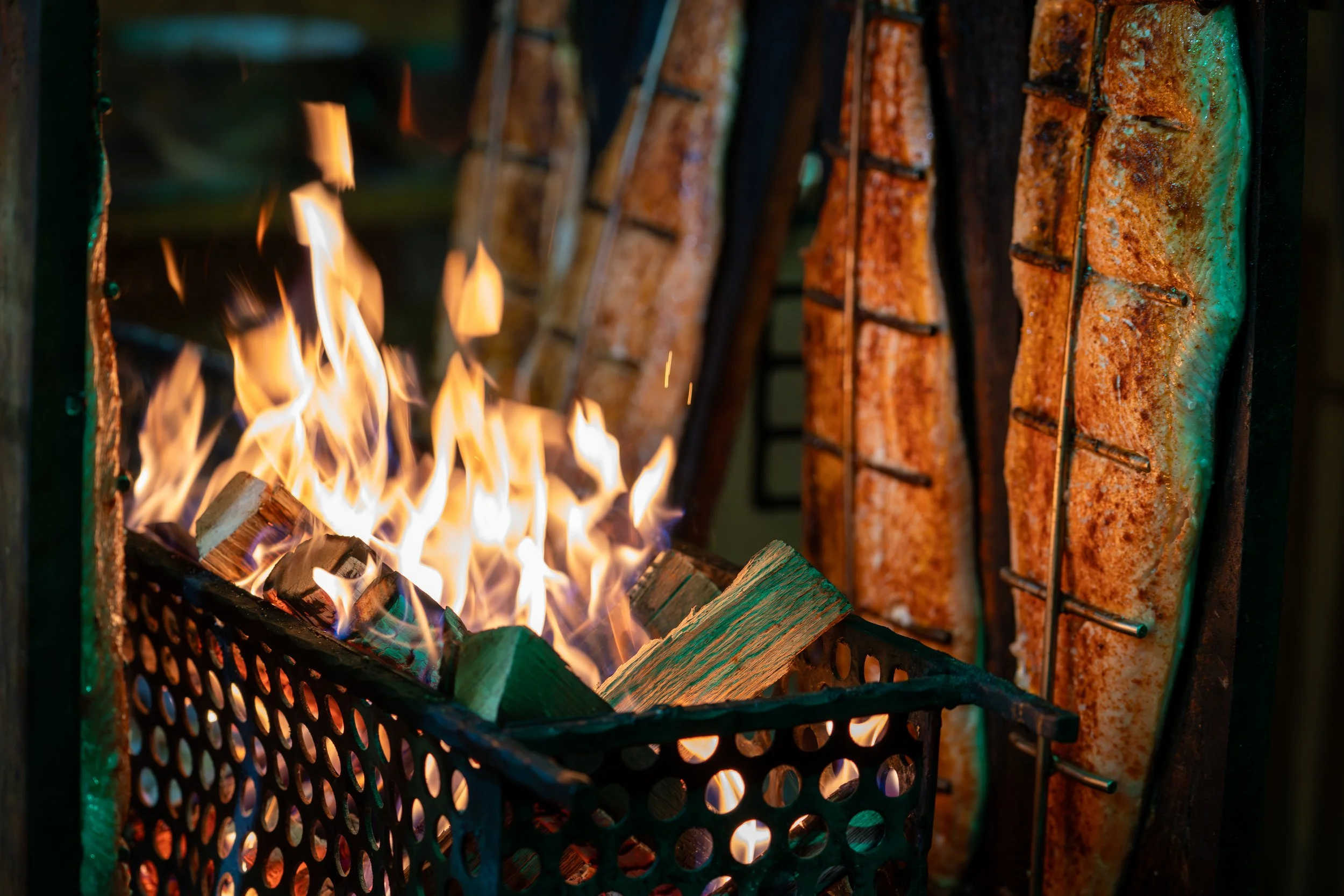 Grill mit brennendem Feuer und abonnierten Fischen auf einem Rost
