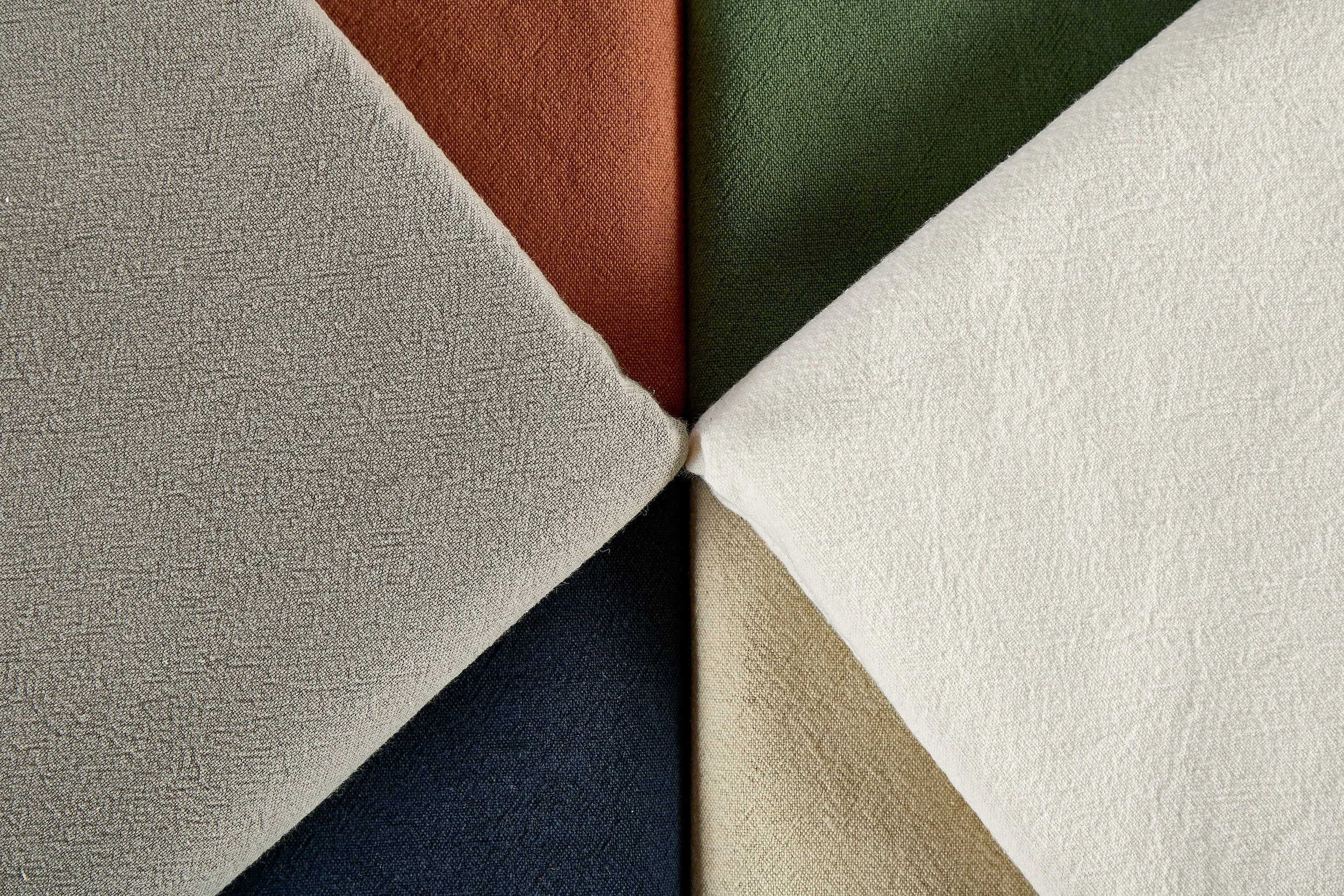 Multiple dyed color blocks of 30% linen 70% cotton textile featuring beige, terracotta, sage green, off-white, and navy blue