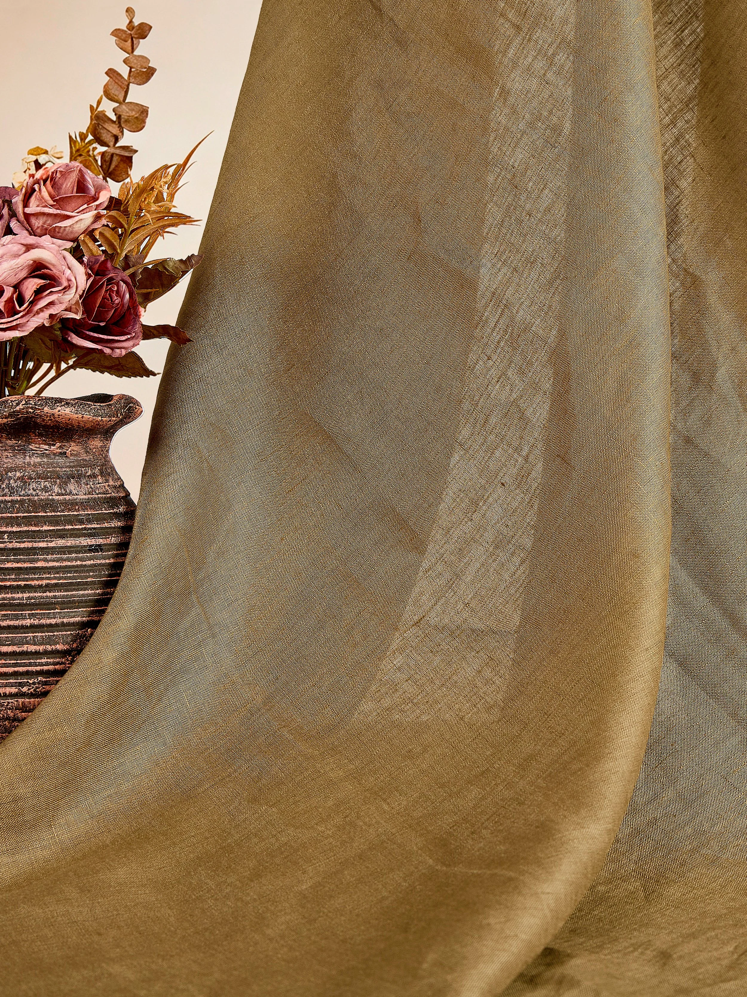 Deep moss green pure linen fabric hanging drape styled with ceramic vase in warm natural lighting