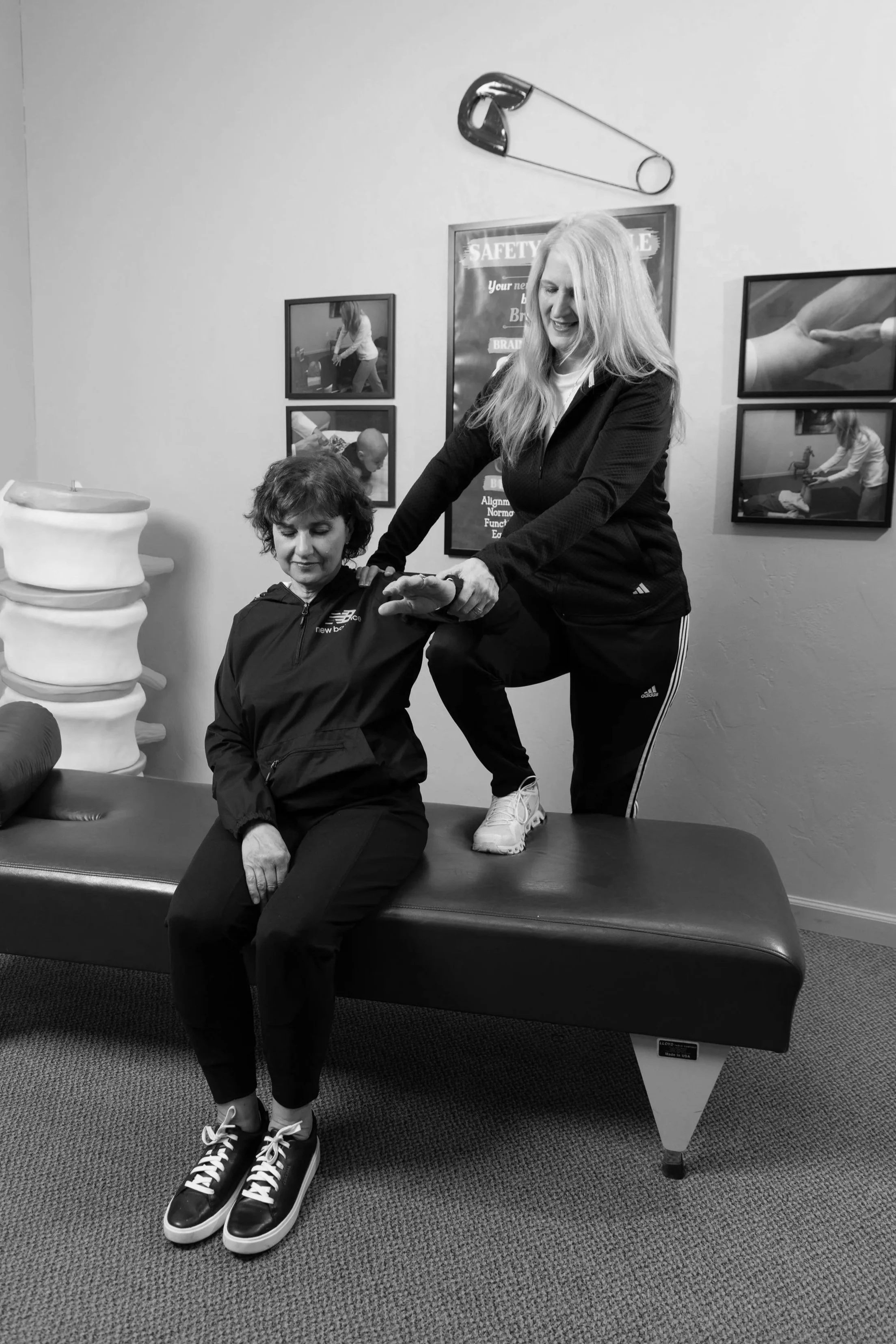 Dr. Kay Miller evaluating a patient’s shoulder and range of motion at Miller Chiropractic.