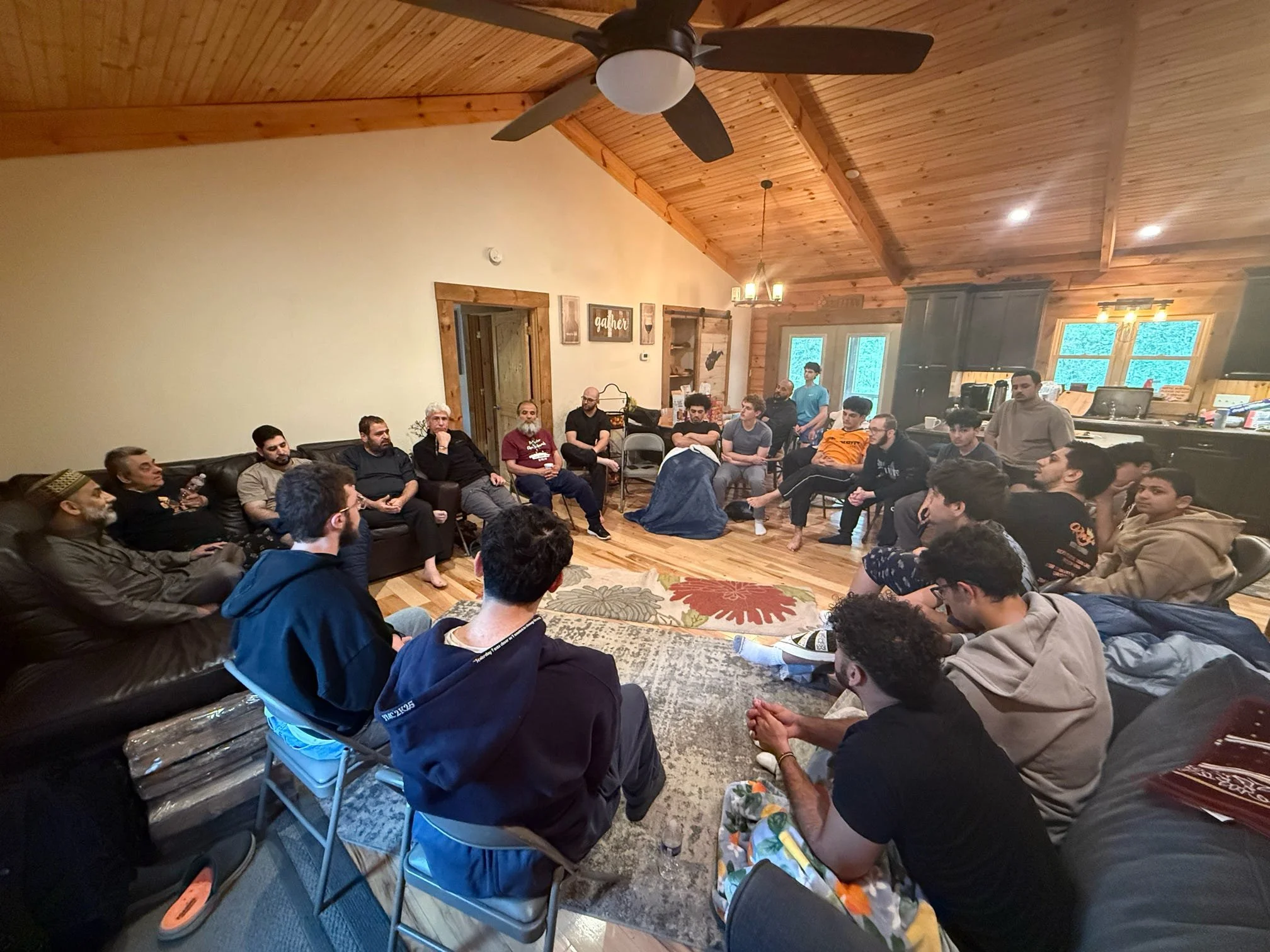 Ali Issa in conversation with a group gathered in a living room, reflecting the kind of thoughtful questions, honest dialogue, and community that often grow around a shared space.