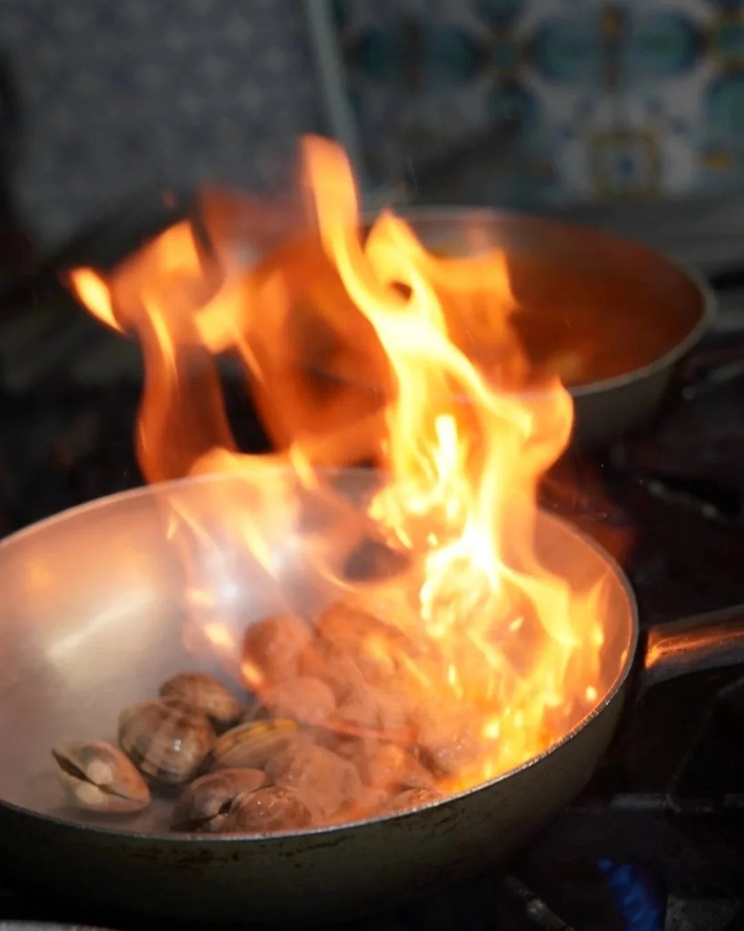 Skillet in flames with sauteed clams