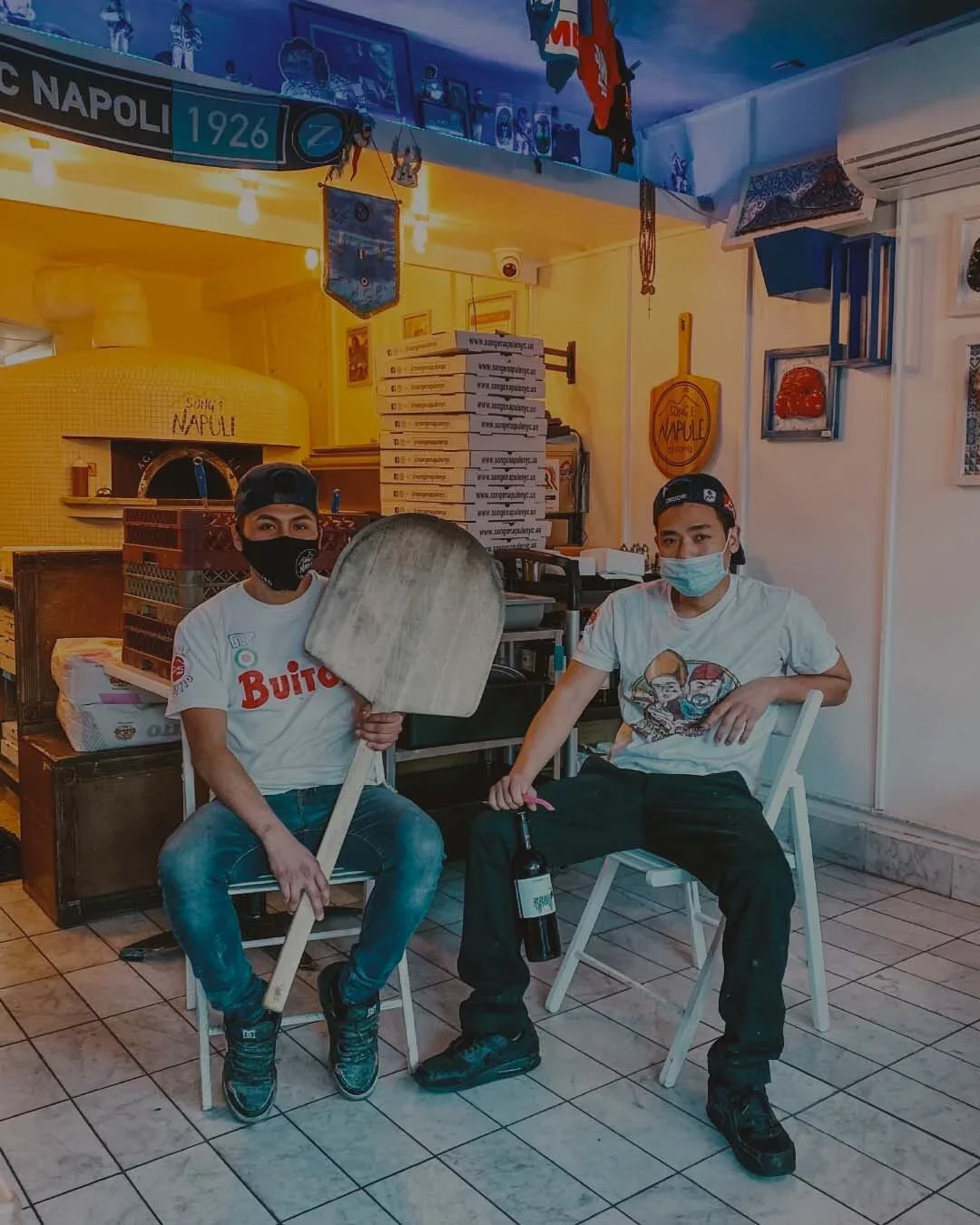 Giggino and Gennaro seating down with a Pizza peel