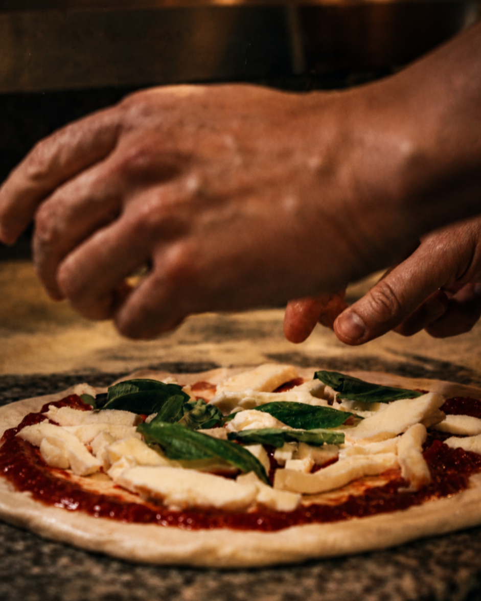 close up of Hands making a margherita pizza ready to put inside the oven