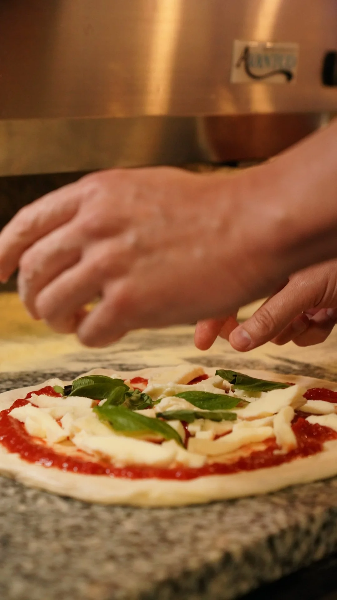 Close up of hands making a margherita pizza ready to put inside the oven