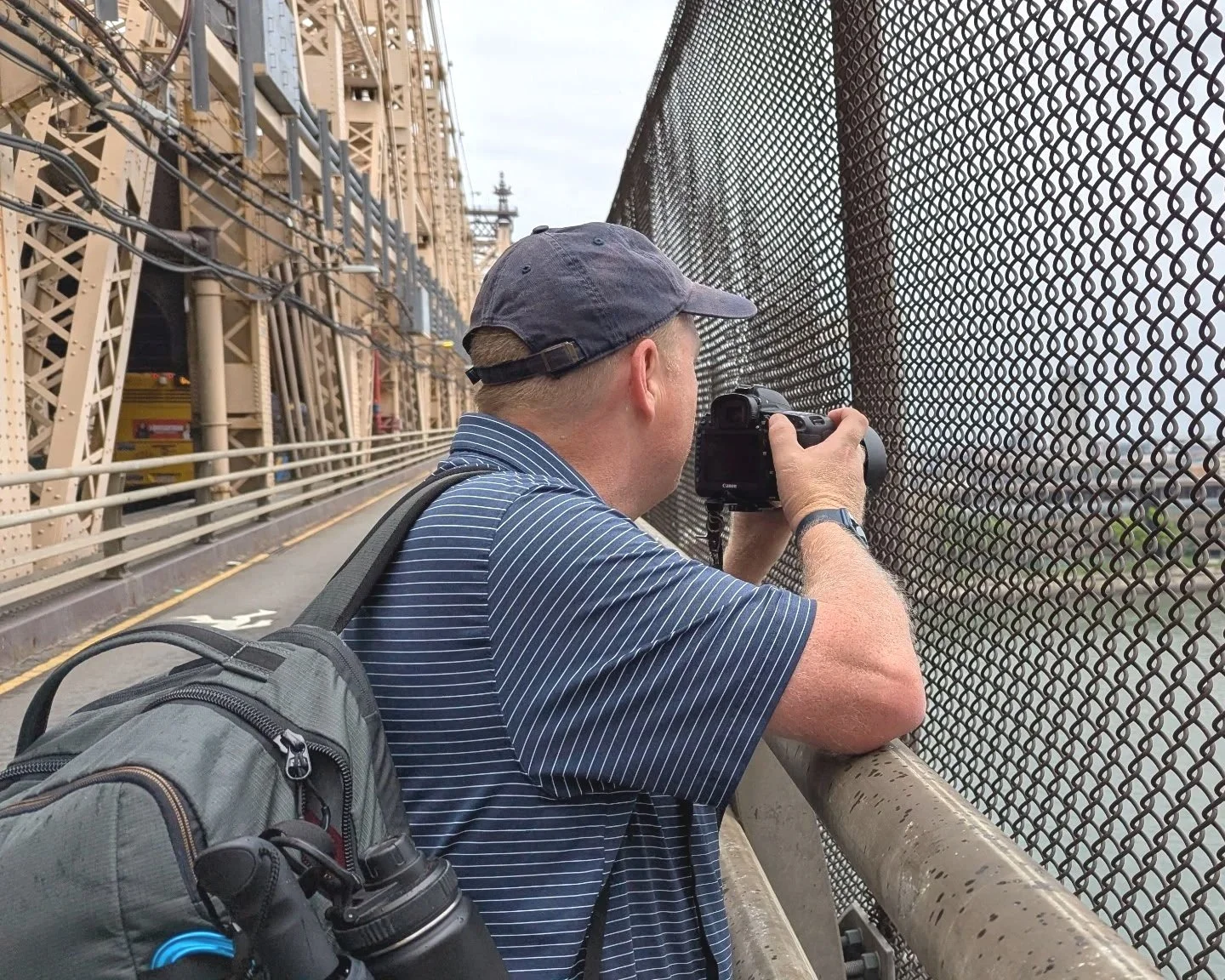 John photographs Roosevelt Island through a fence while working on a Story Behind The Place feature.