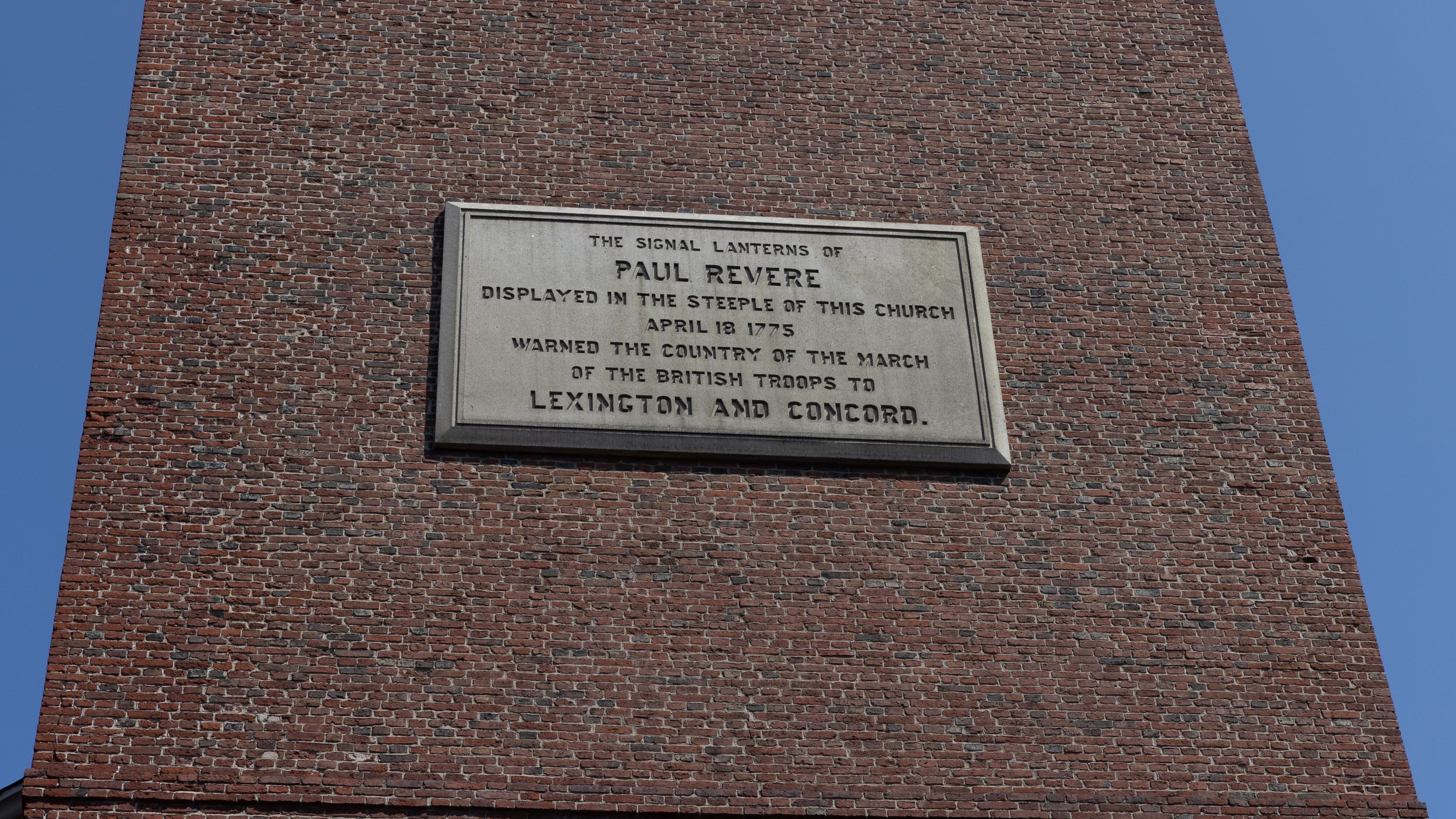 Stone plaque on Old North Church stating that Paul Revere’s signal lanterns warned of the British march to Lexington and Concord.