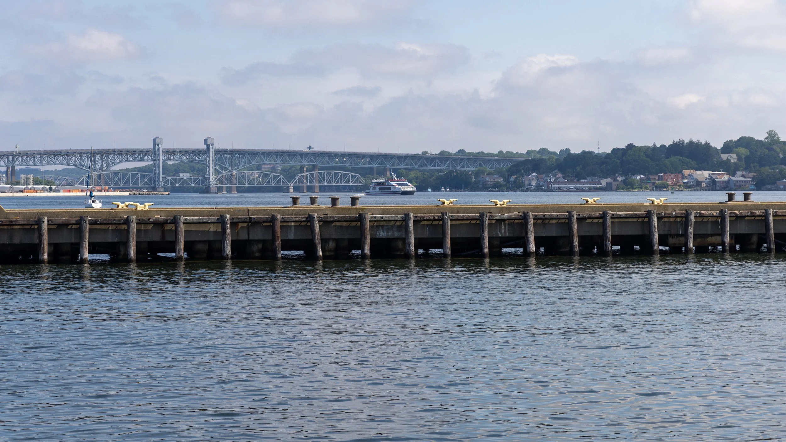 I-95 bridge spanning the Thames River beyond a long pier between New London and Groton.
