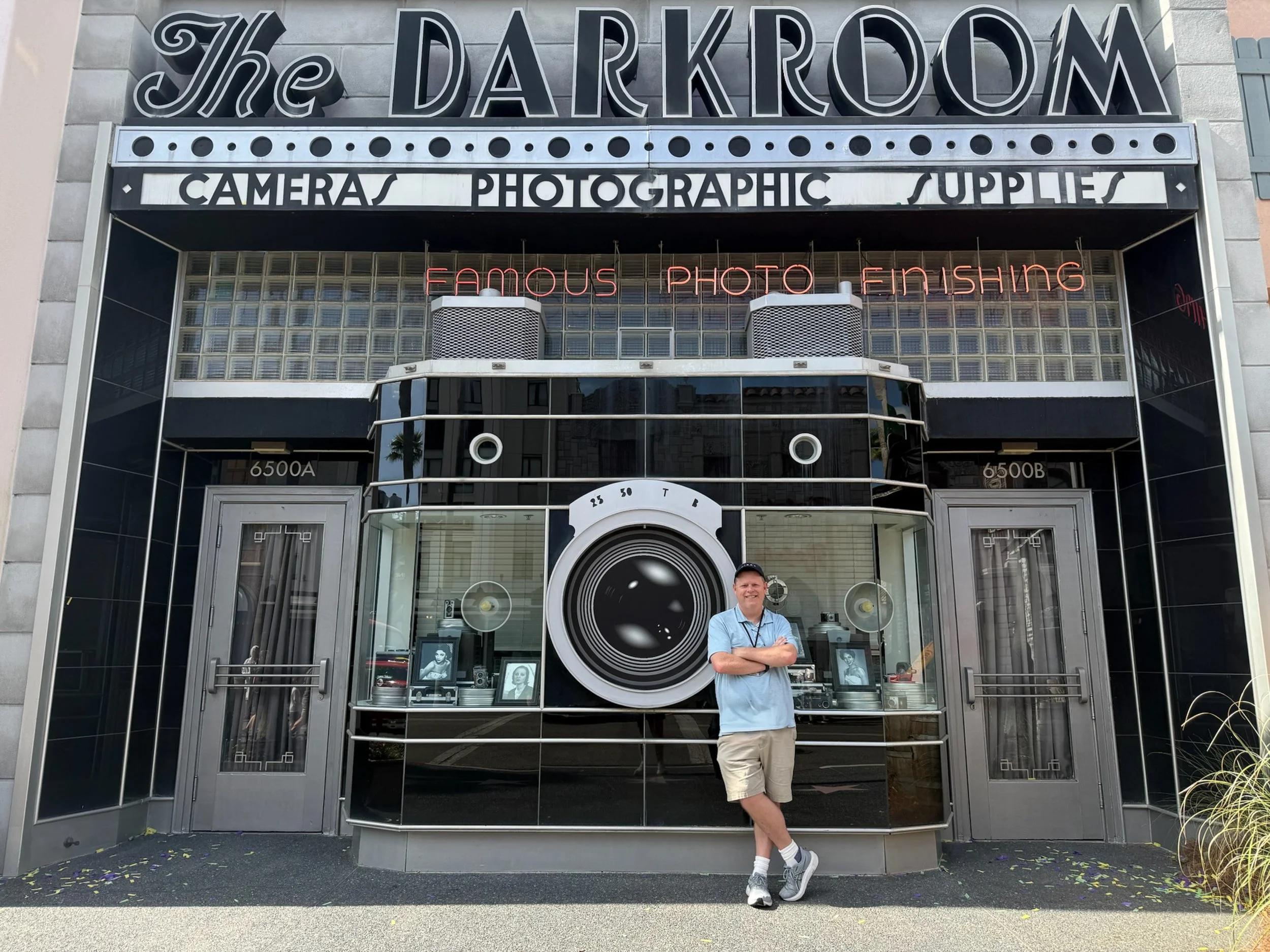 John Menzies standing in front of The Darkroom photography storefront at Universal Studios Florida in Orlando.