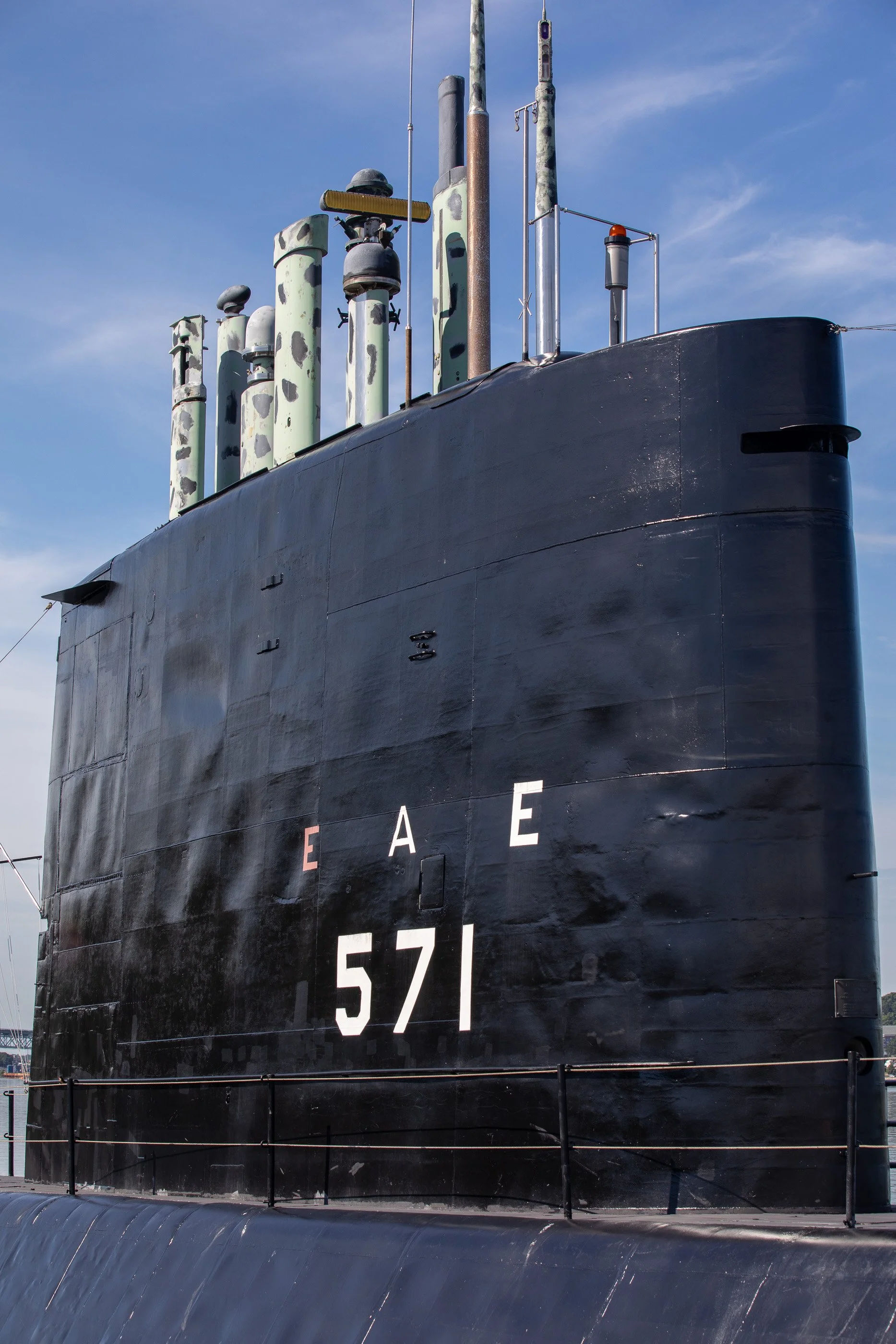 Close view of the black sail of USS Nautilus marked 571 against a blue sky in Groton, Connecticut.