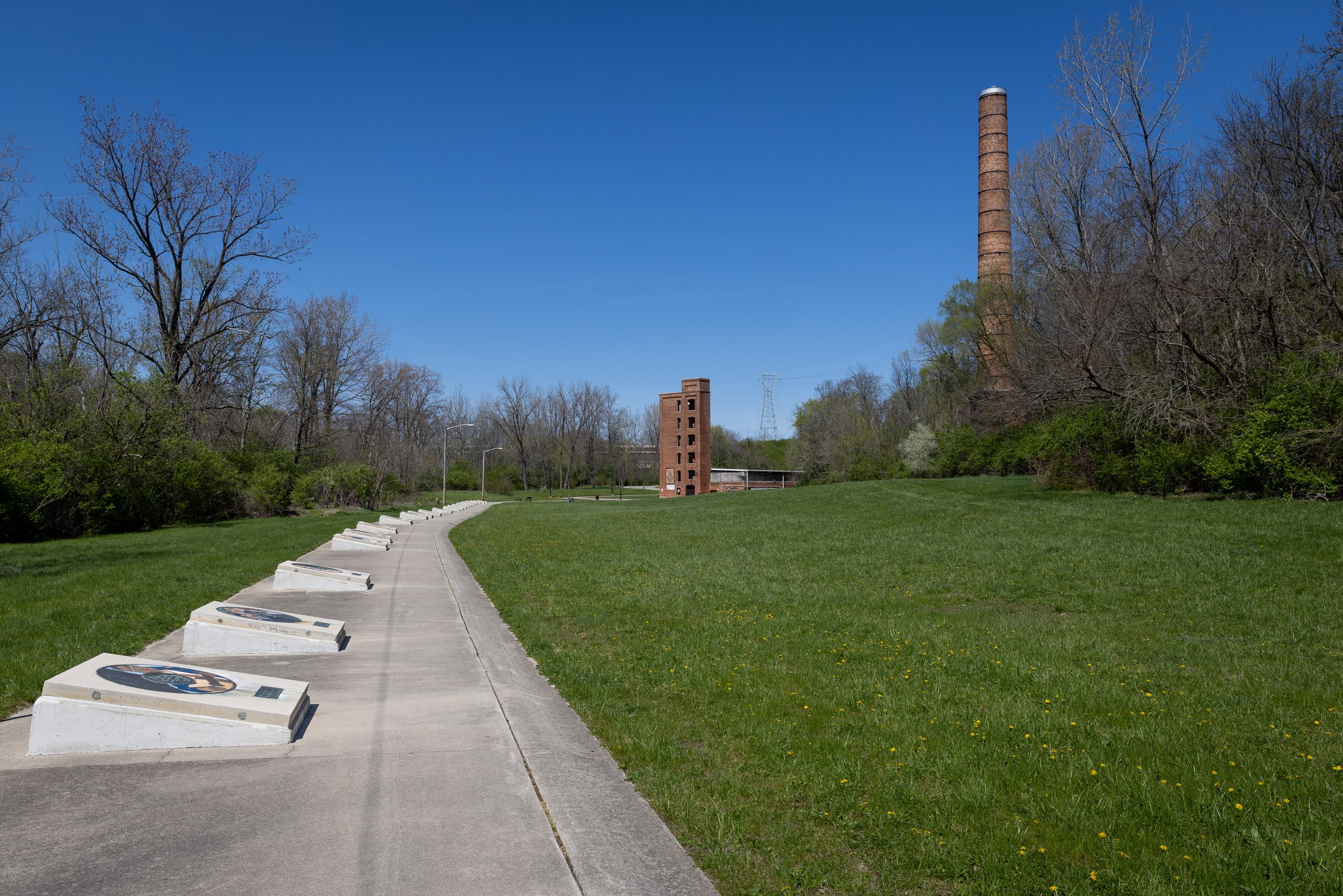 Record-shaped markers line the Starr-Gennett Walk of Fame leading toward the surviving brick factory structures and smokestack.