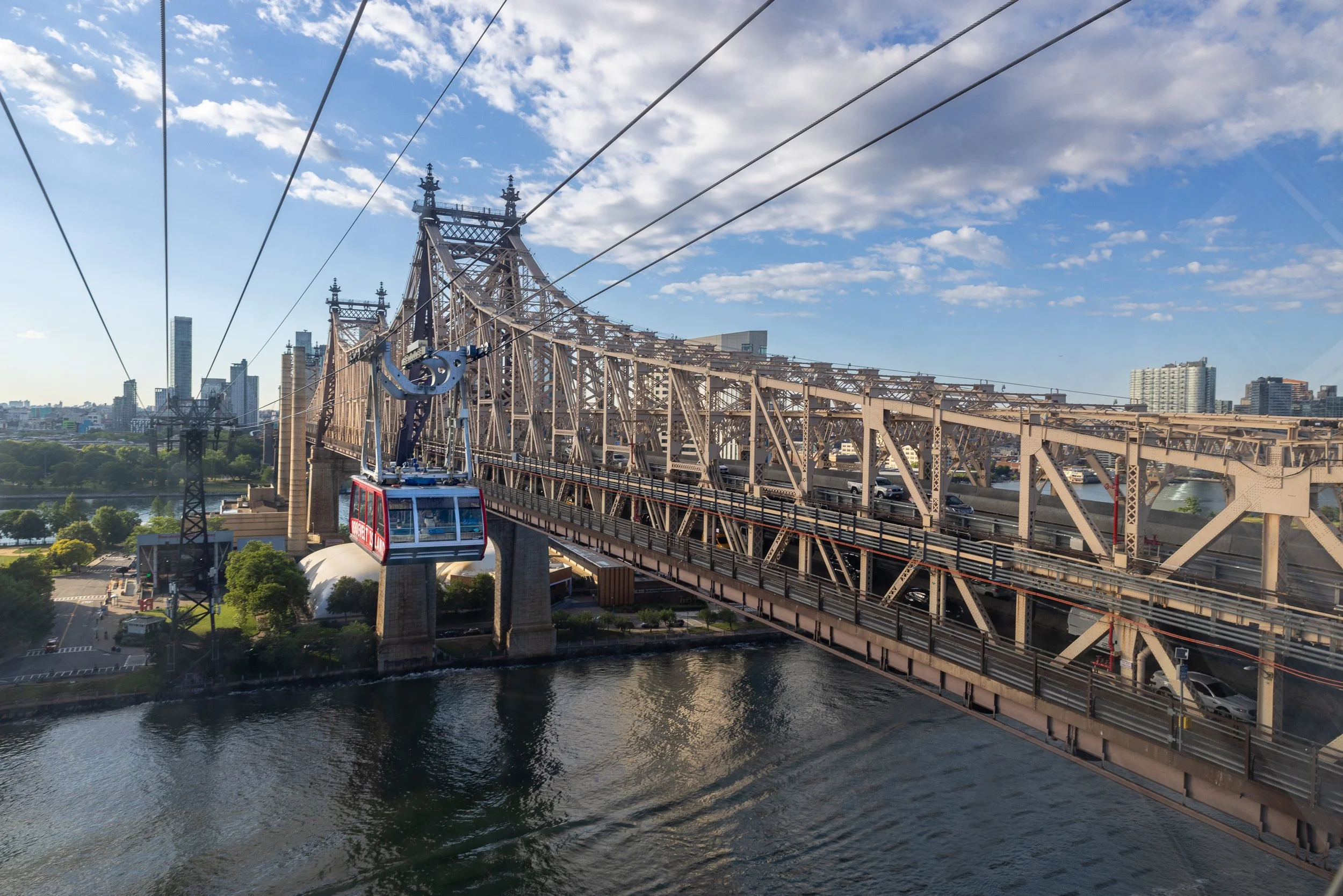 The tram and Queensboro Bridge run almost side by side as they approach the island. The bridge arrived first in 1909; the aerial tram followed in 1976 as a supposedly temporary solution to a subway that was still years away.