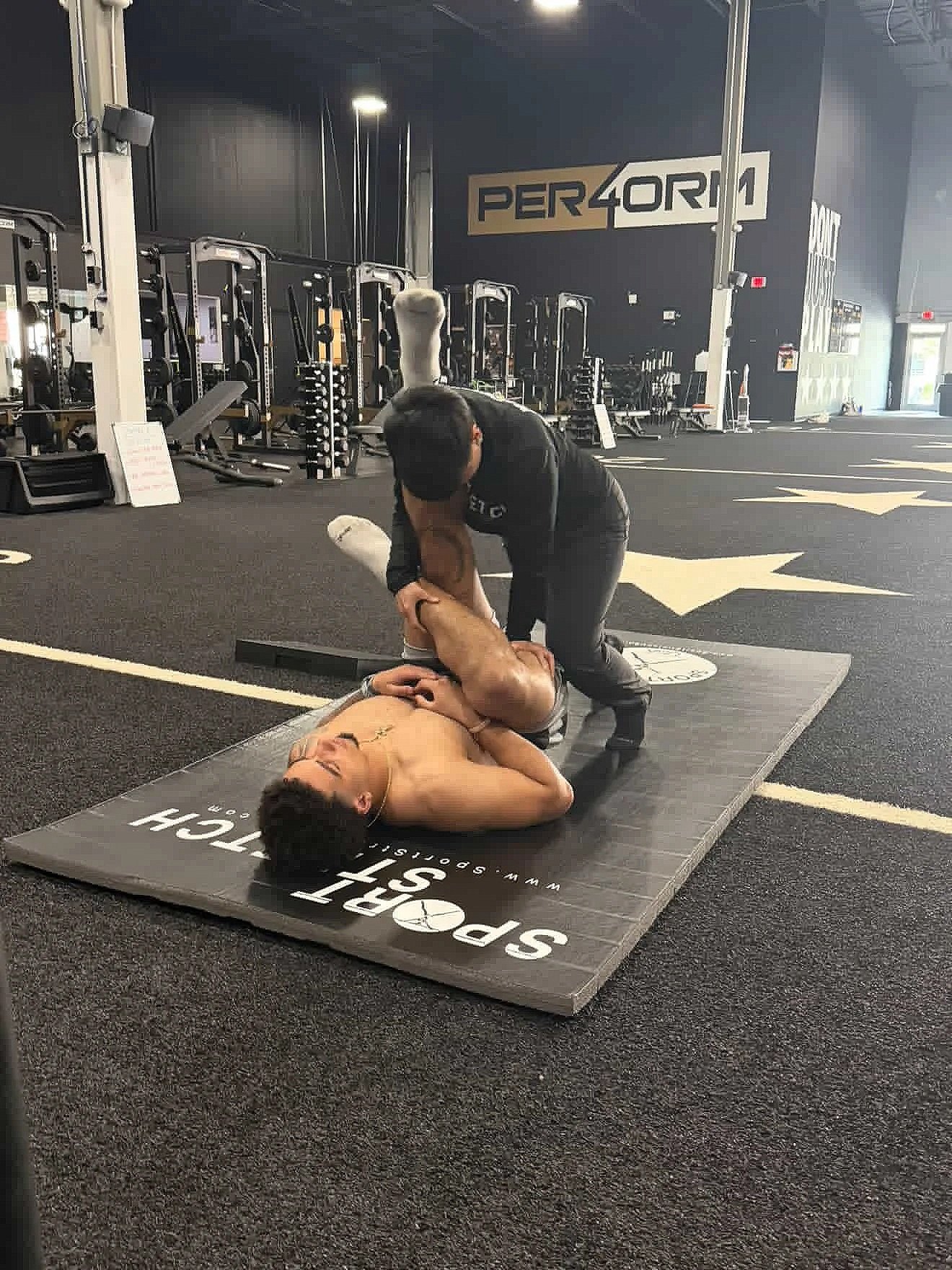 Photo of a woman doing an assisted sports stretch on an athlete