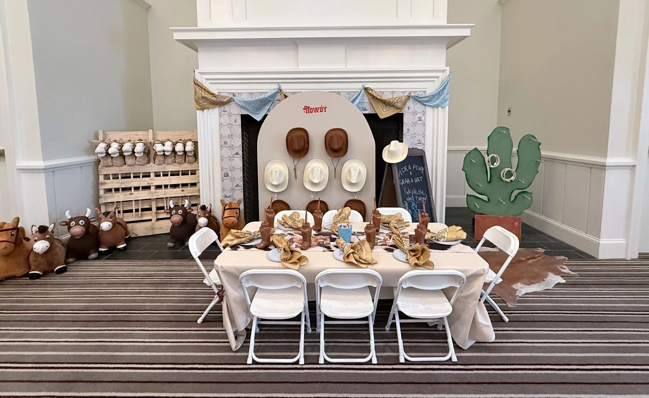 Western-themed dessert table with cowboy hats and cow decor styled by Wildly Pretty Events