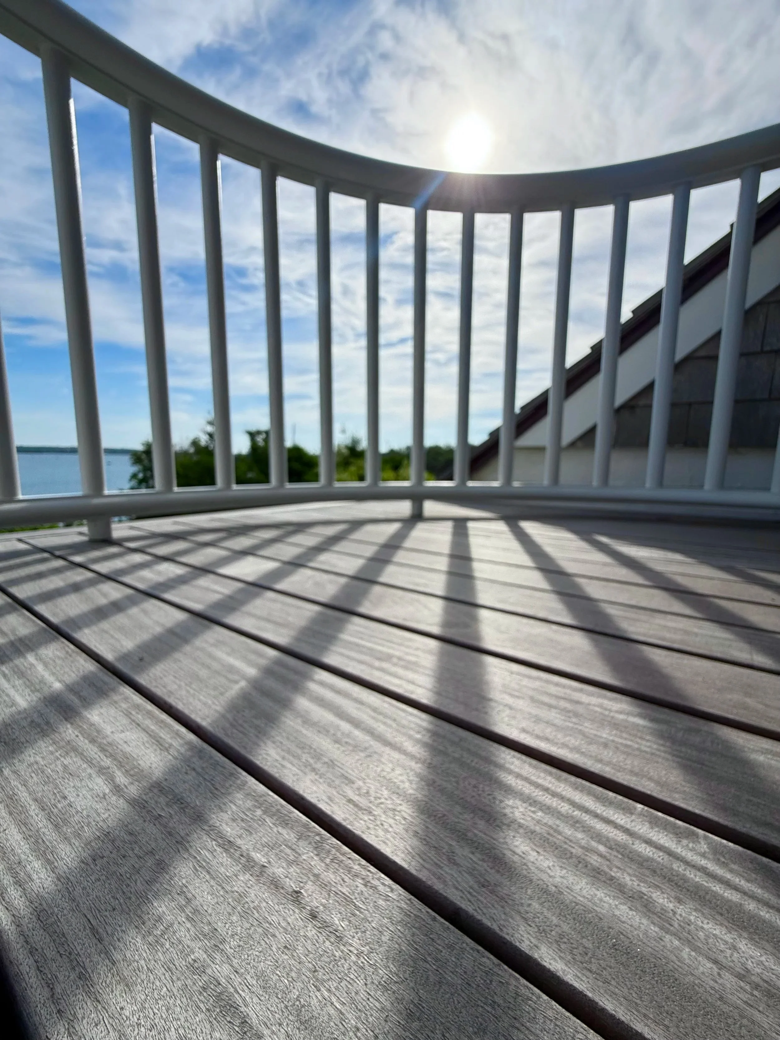 Weathered Ipe narrow board deck balcony on an Owen's Corning OC Lumber frame with custom curved mahogany hand rails on Block Island RI 