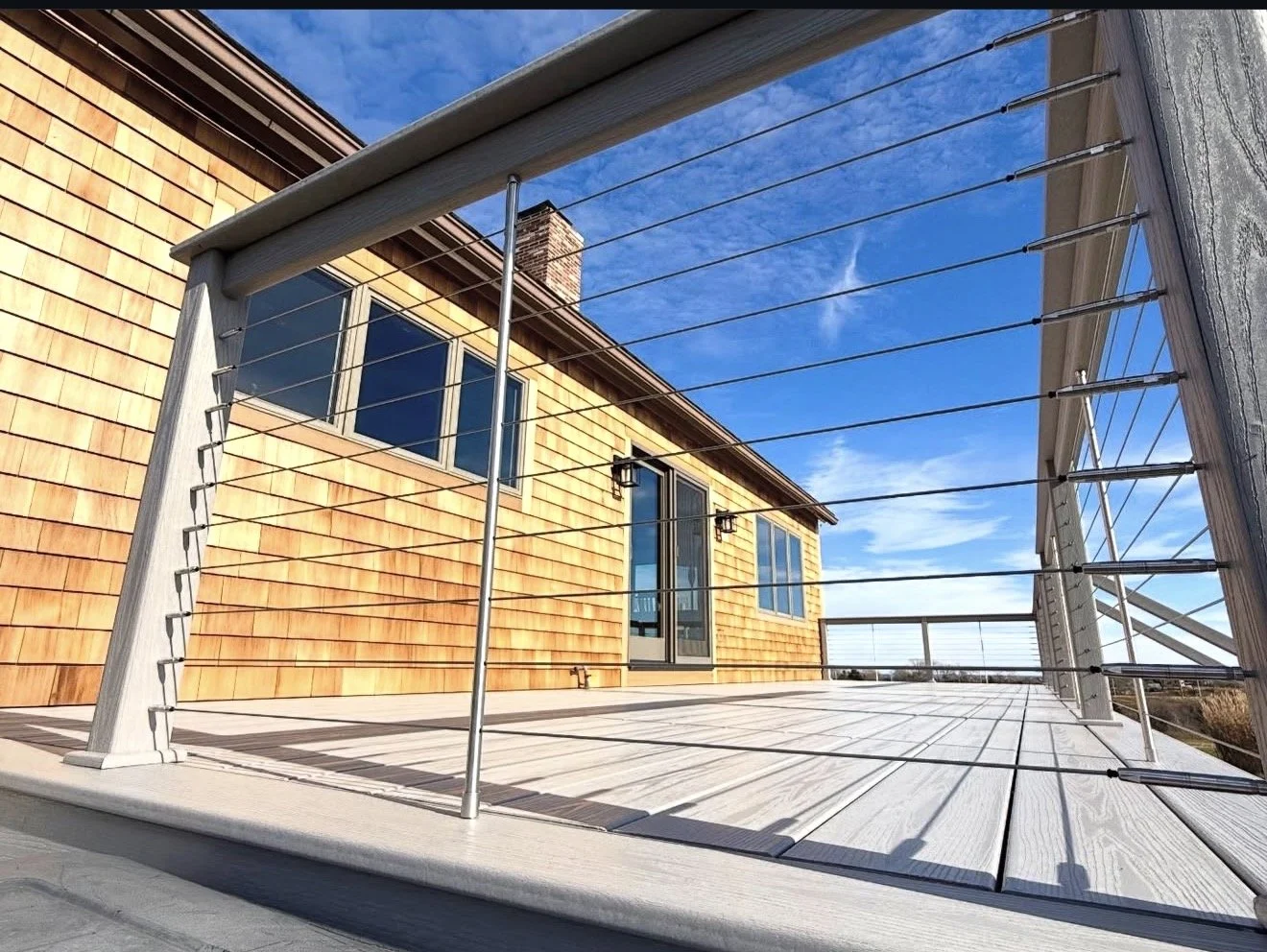 Owen's Corning OC lumber deck with Feeney stainless steel cable rails and drink rail in gray on Block Island RI 