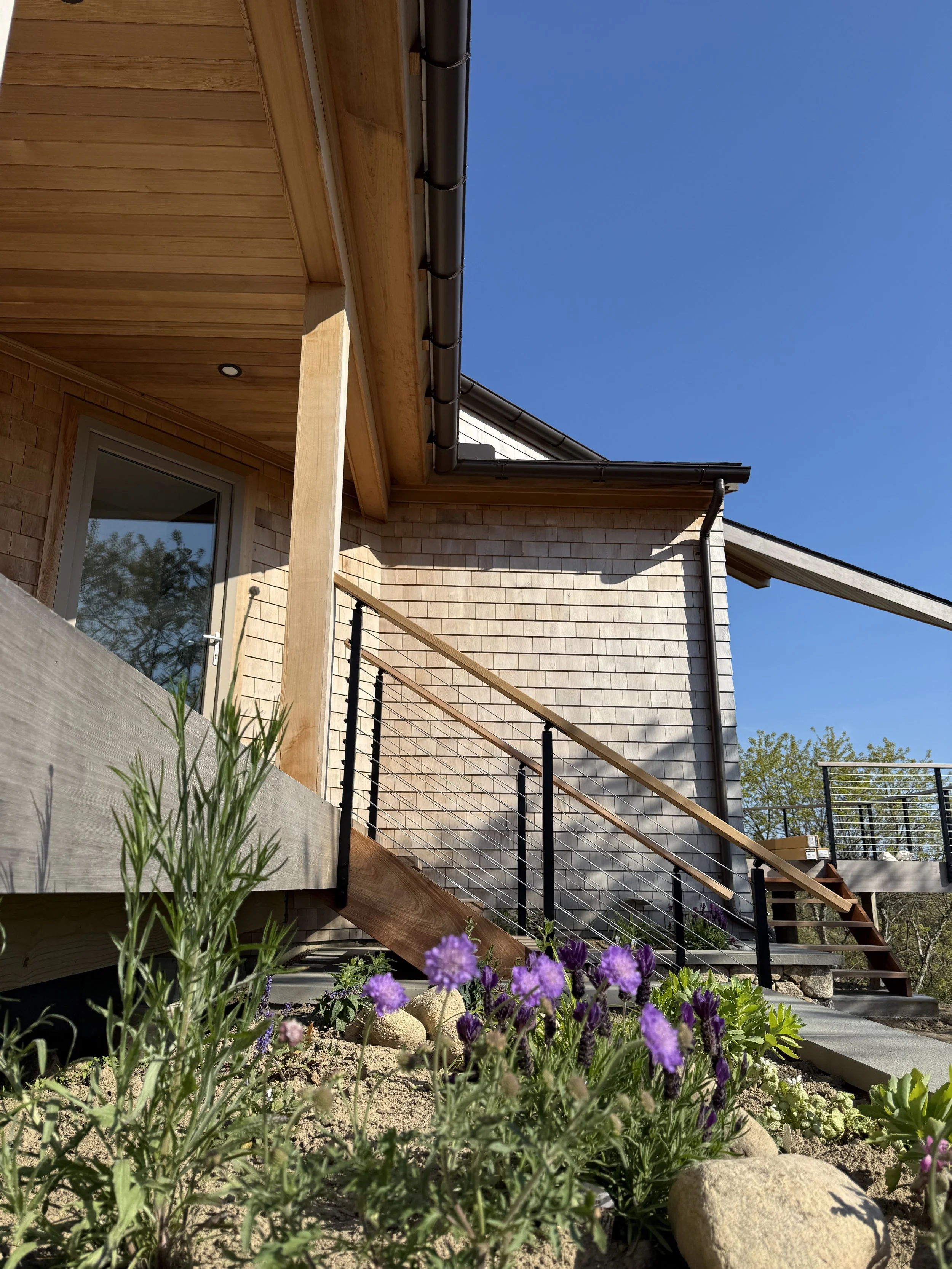 Accoya deck with western red cedar trim and custom mahogany stairs with Atlantis cable rails and fascia mounted posts on Block Island RI 