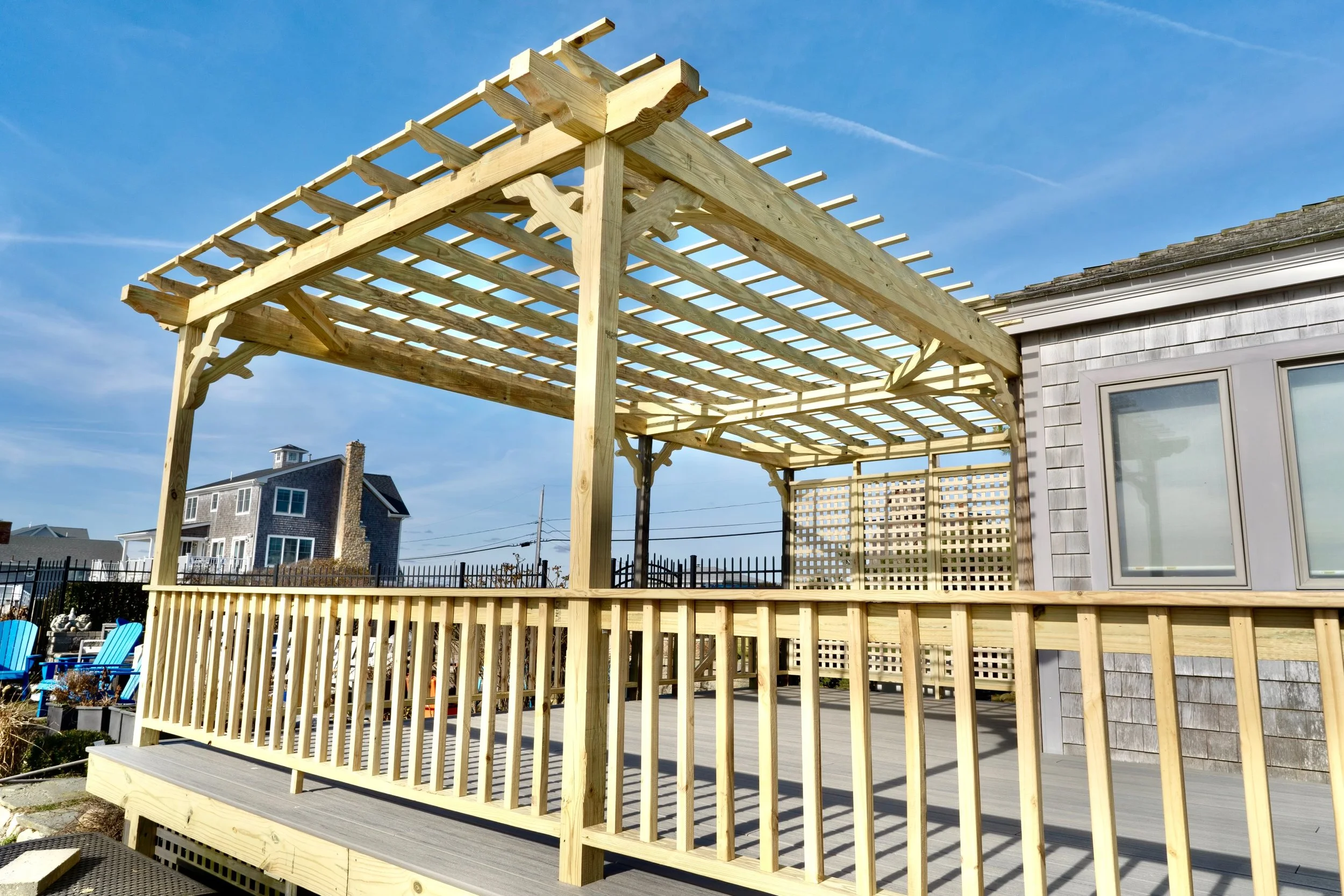custom built pergola over coastal deck with arched feature and seagull decorative braces in Matunuck RI