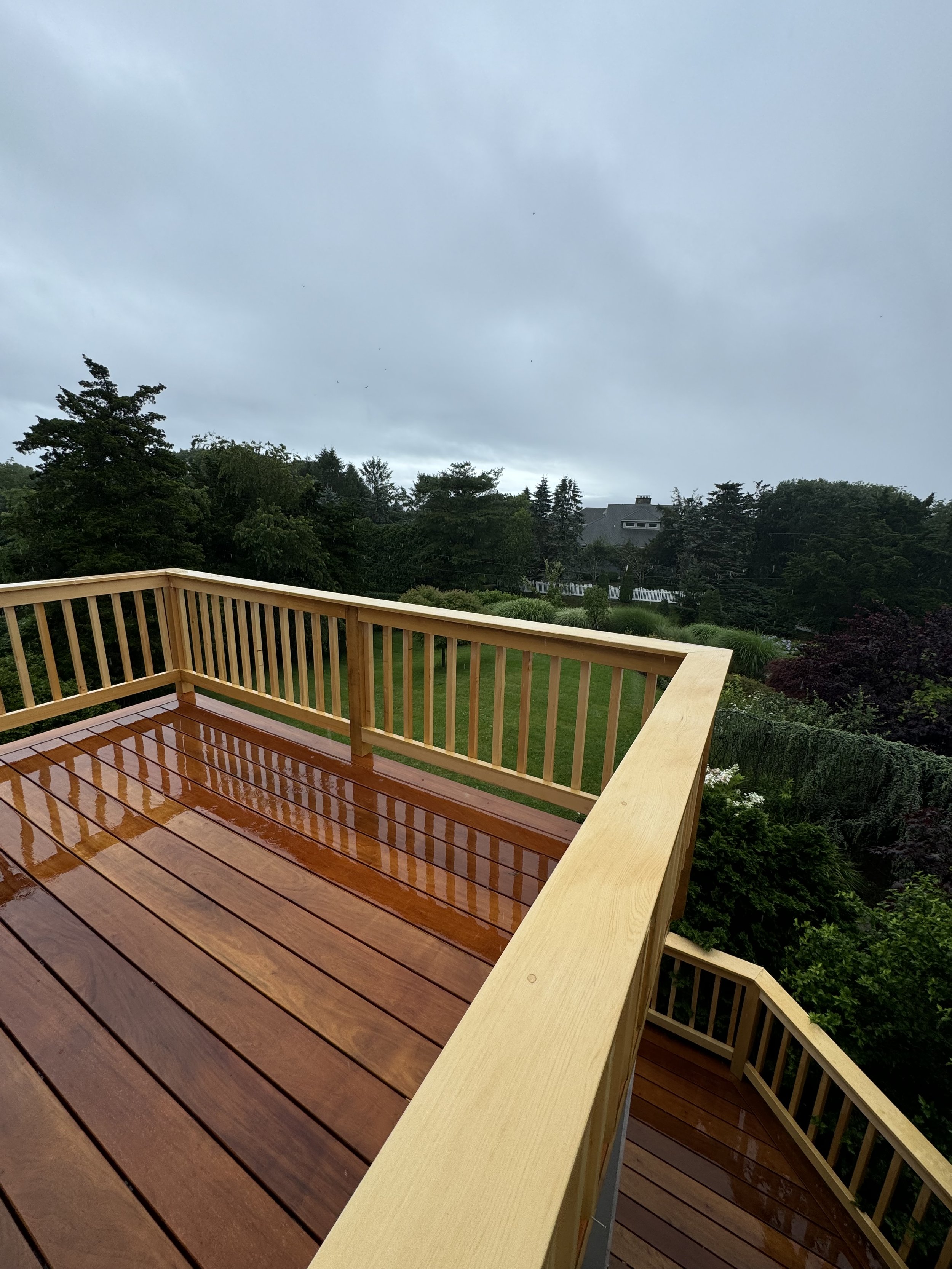 Garapa tropical hardwood deck with hidden clip fasteners and custom Alaskan Yellow Cedar rails with drink rail