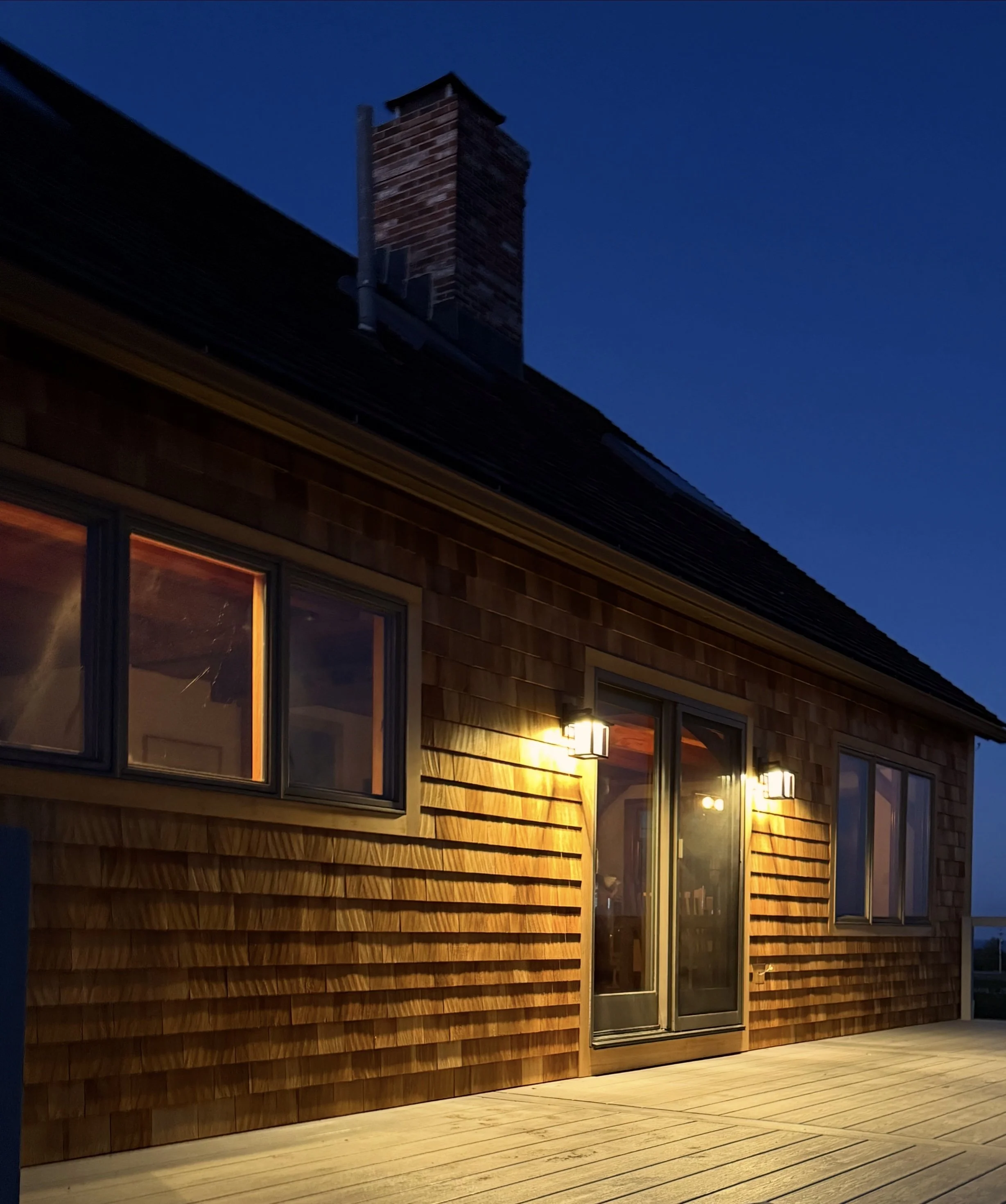 Owen's Corning OC Lumber deck with Feeney stainless steel cable rails and drink rail in gray on Block Island RI photographed at night 



