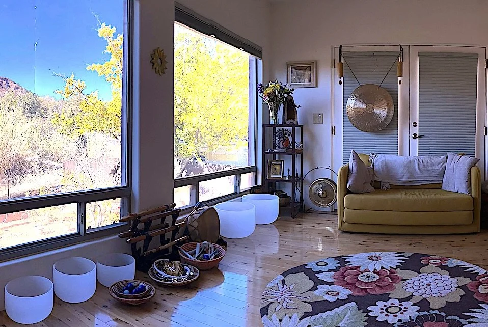 Cozy Sedona coaching space with sofa, rug, and red rock views.