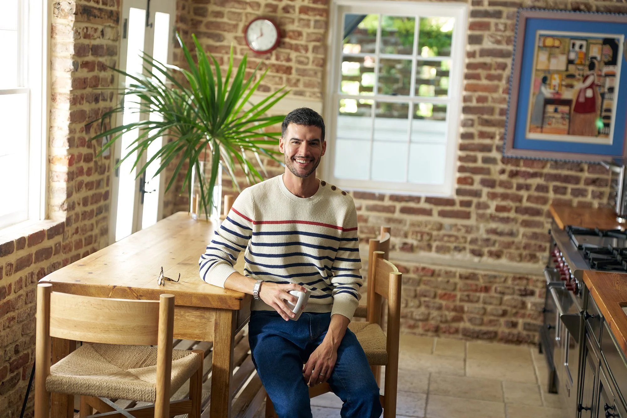Ryan sitting at a dining room table holding a mug.