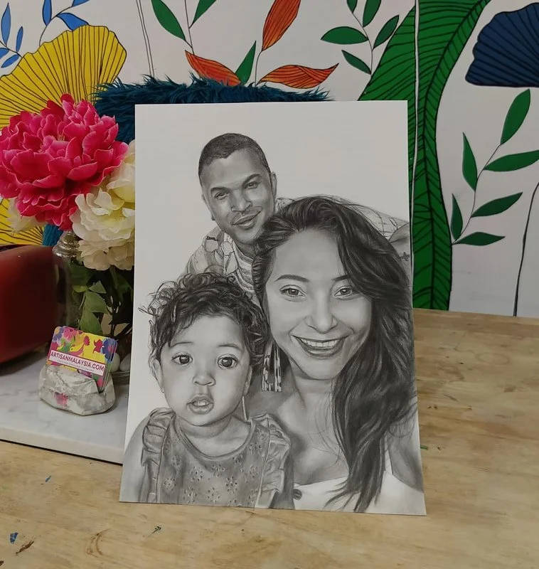 A detailed pencil drawing of a smiling woman's face, a toddler boy with curly hair, and a man with short hair, set against a colorful floral background.
