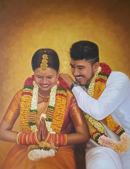 A smiling Indian couple dressed in traditional wedding attire, with flower garlands, in front of a plain yellow background.