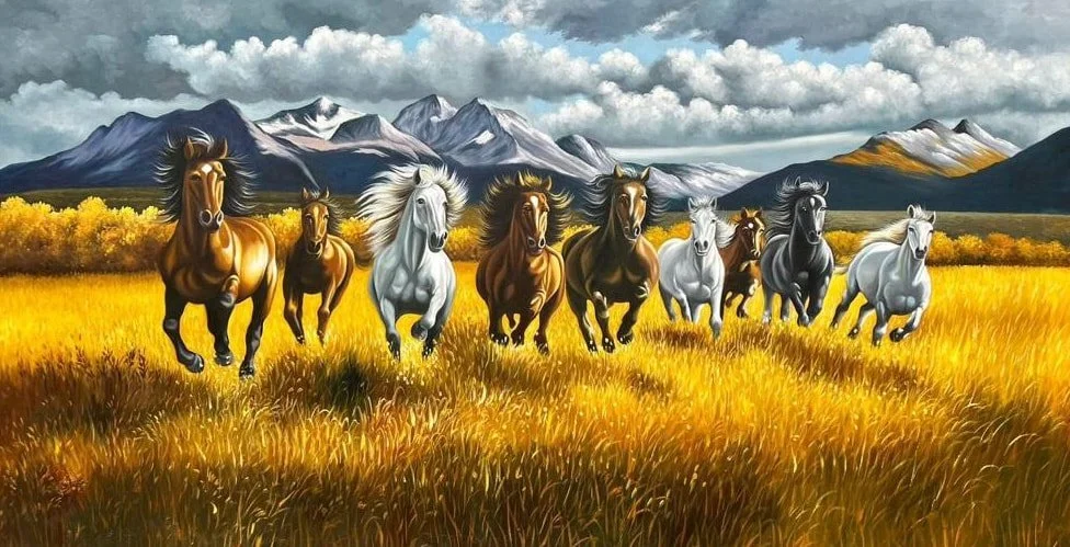 A herd of eight horses running across a golden field with mountains and clouds in the background.