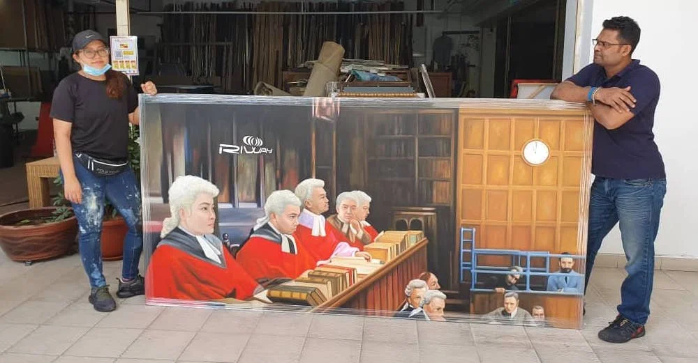 Two people standing on either side of a large, detailed painting depicting a courtroom scene, with judges wearing red robes, a judge's clock on the wall, and courtroom staff and visitors.