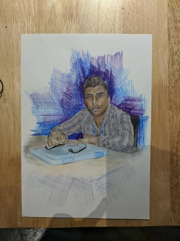 Color pencil drawing of a young man sitting at a table with a pair of glasses and a box in front of him, against a background of blue and purple strokes.