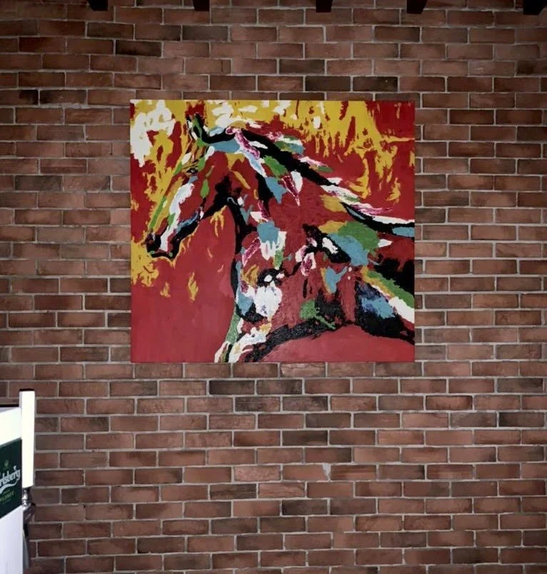 Painted artwork of a horse on a brick wall.
