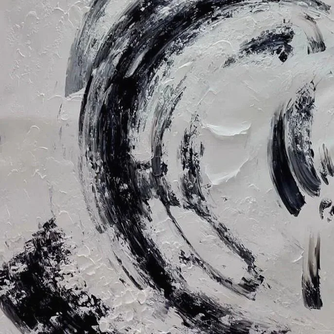 Close-up view of abstract black and white textured painting with bold, sweeping brushstrokes.
