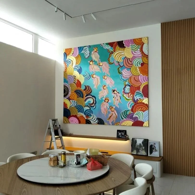 A modern dining area with a round table, white chairs, and a large colorful painting of abstract clouds and pink figures on the wall.