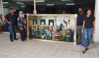 Four people standing beside a large framed painting displayed indoors.