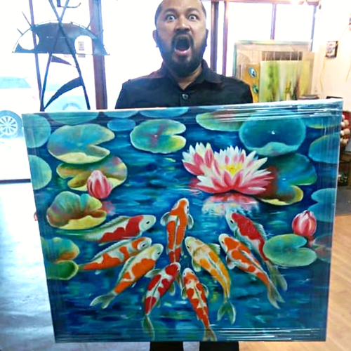 A man with a beard and mustache, wearing a black shirt, stands behind a colorful painting of water lilies and koi fish. The man has his mouth open with a surprised or expressive look, and the background shows a bright window with some objects and art