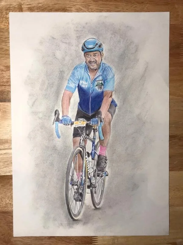 Hand-drawn illustration of a man riding a bicycle, wearing a blue helmet, blue cycling jacket, shorts, and pink socks, on a neutral background.