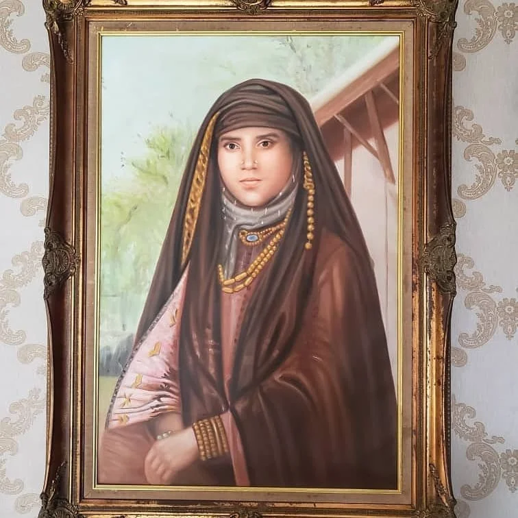 Portrait of a woman in traditional clothing and jewelry, framed in ornate wood frame, with a scenic background.