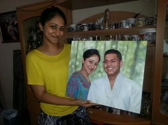 Woman in yellow shirt holding a framed photo of a smiling couple.